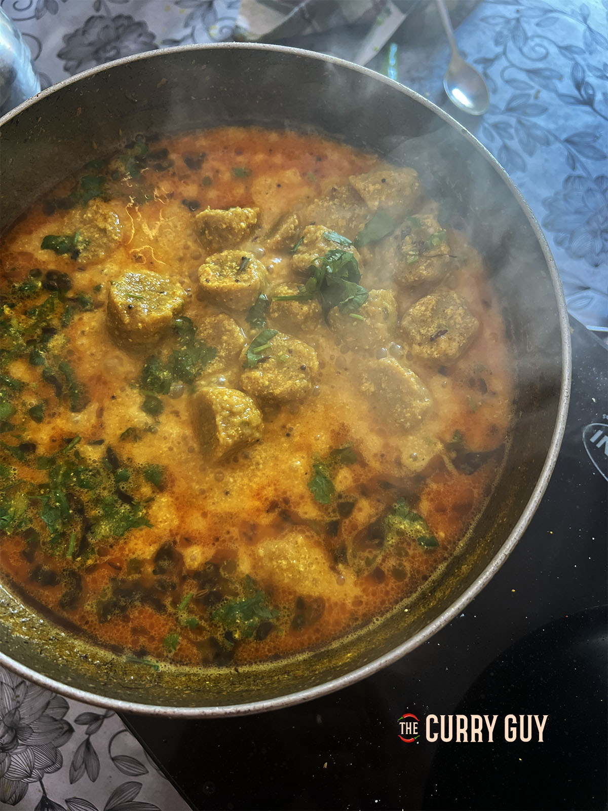 Simmering the dumplings in the yoghurt sauce.