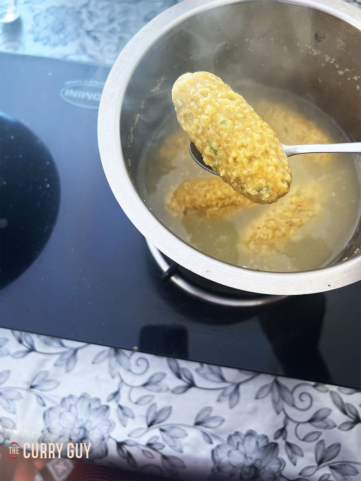Adding the dumplings to boiling water to cook.