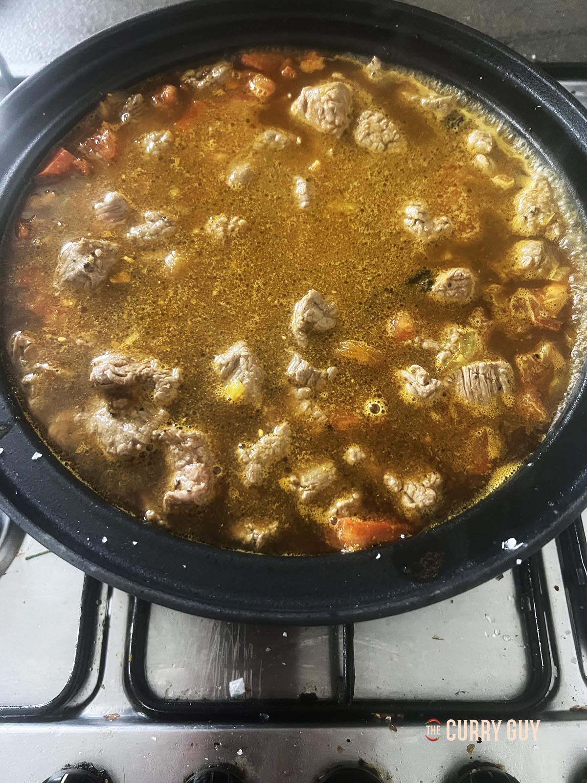 Adding the beef stock to the pot.