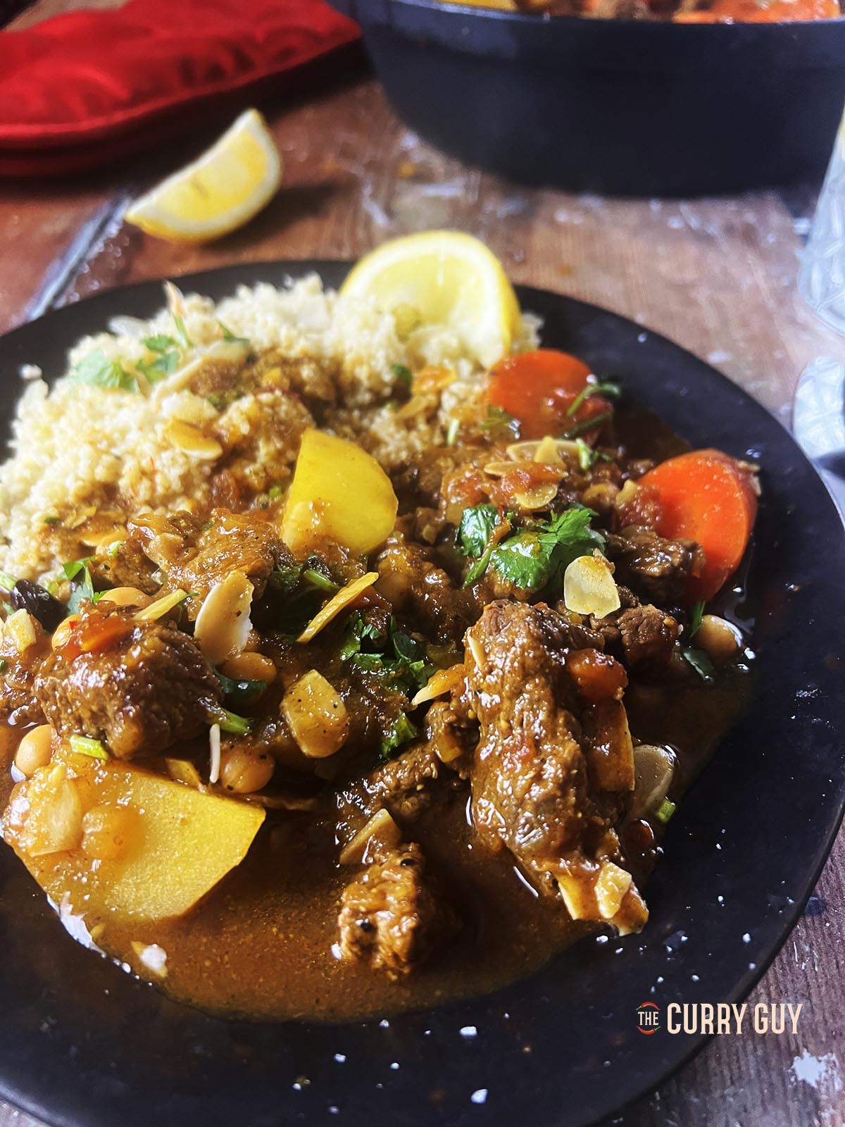Beef tagine served with couscous at the table.