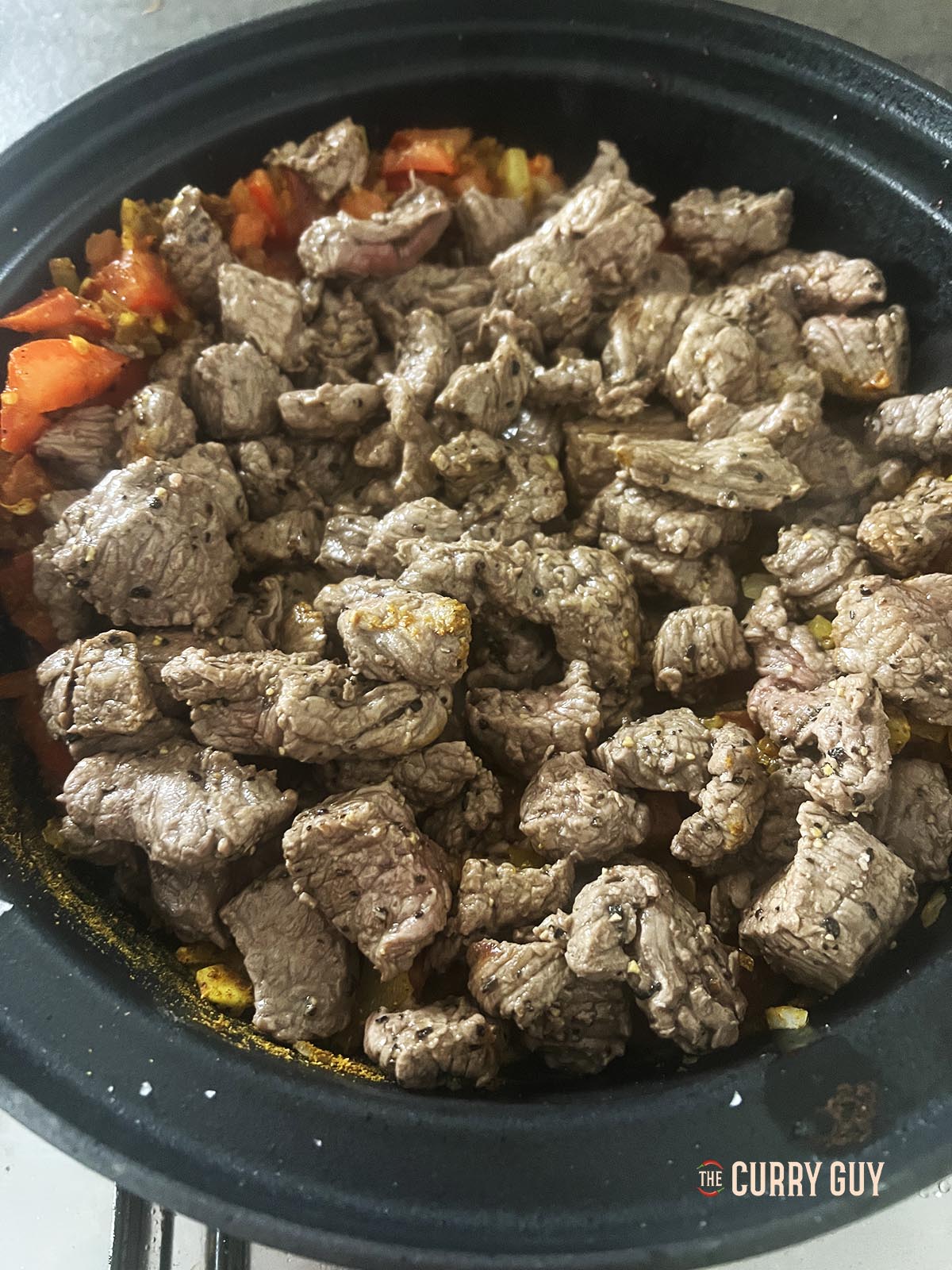 Returning the cooked meat to the pot.