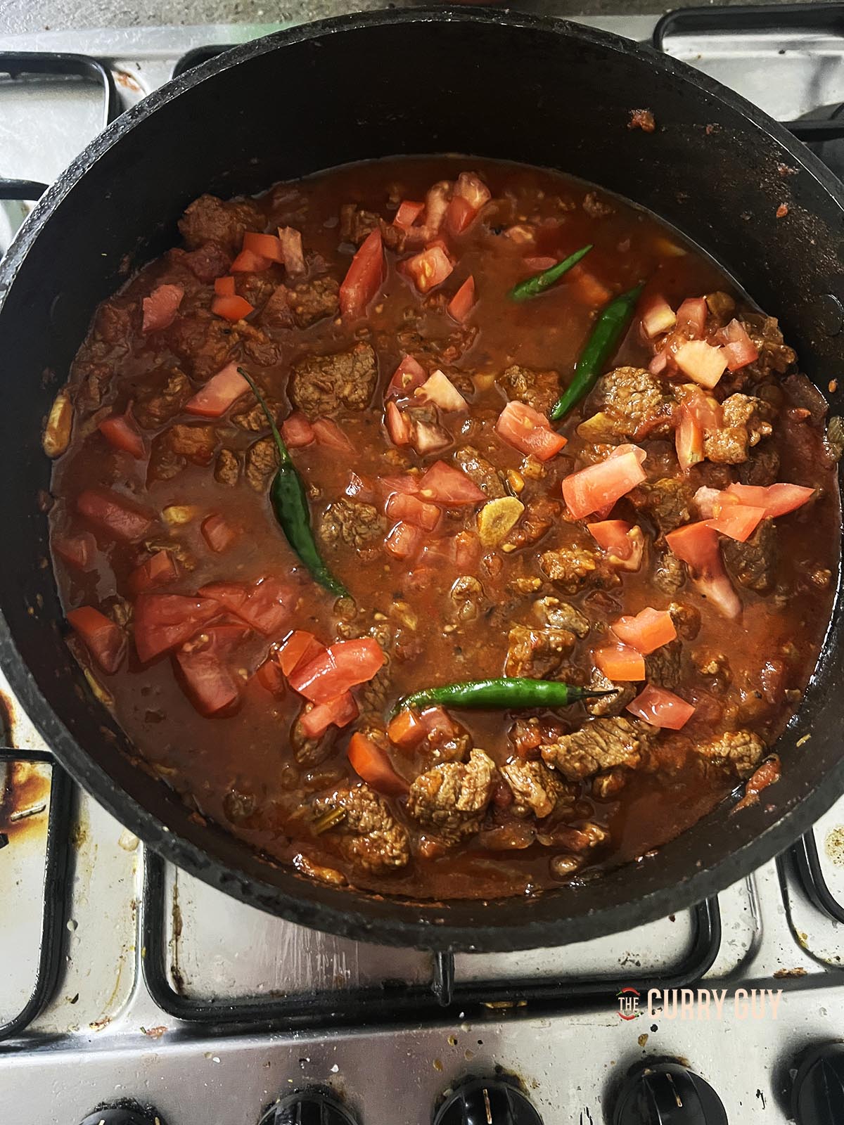 Adding chillies and freshly chopped tomatoes.