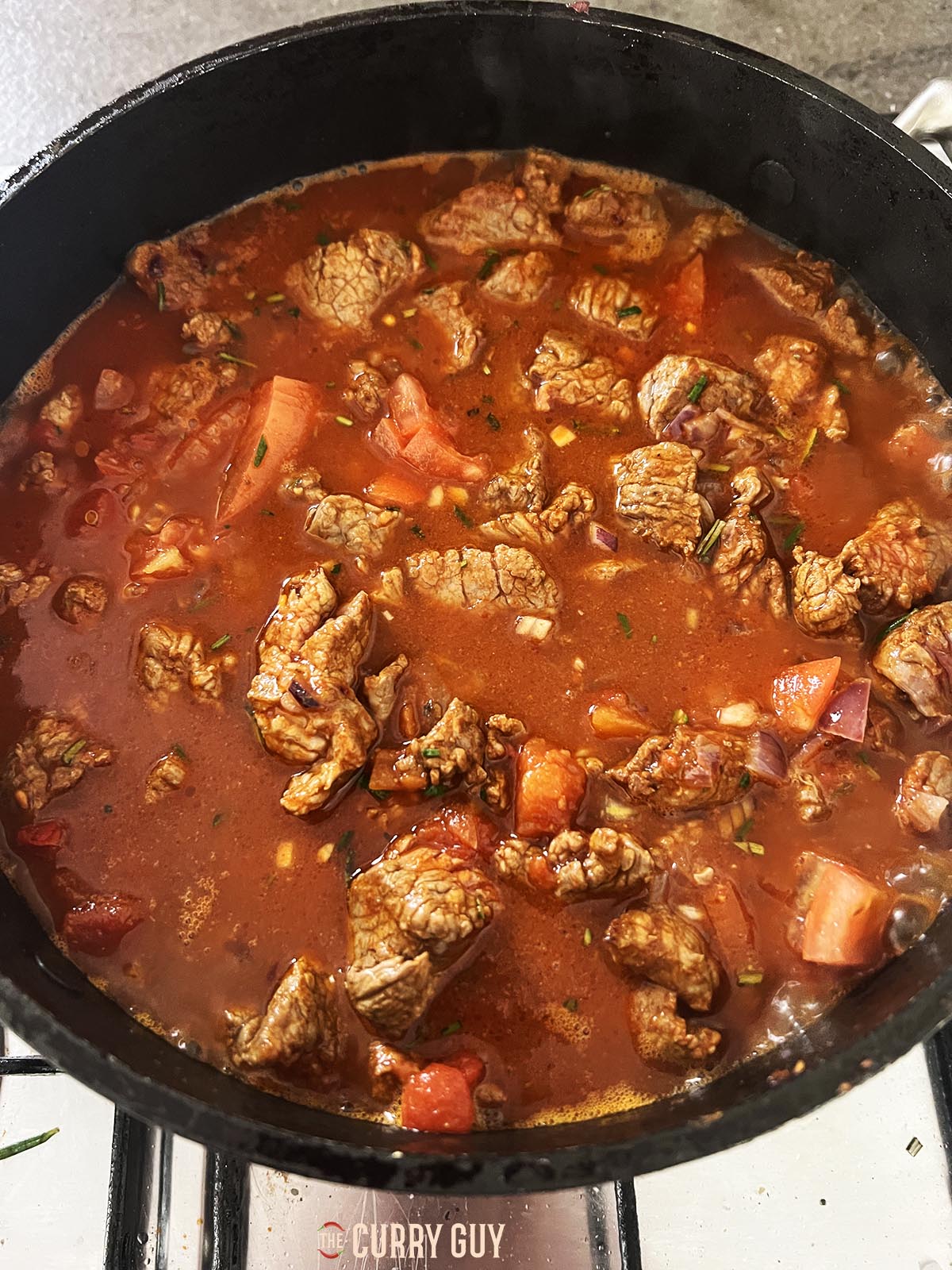 Adding beef stock to the pot.
