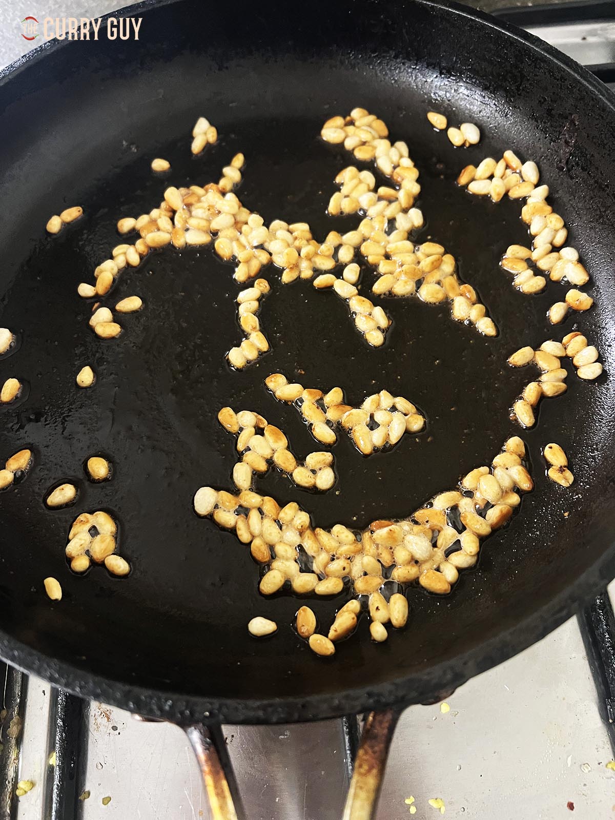 Frying the pine nuts.