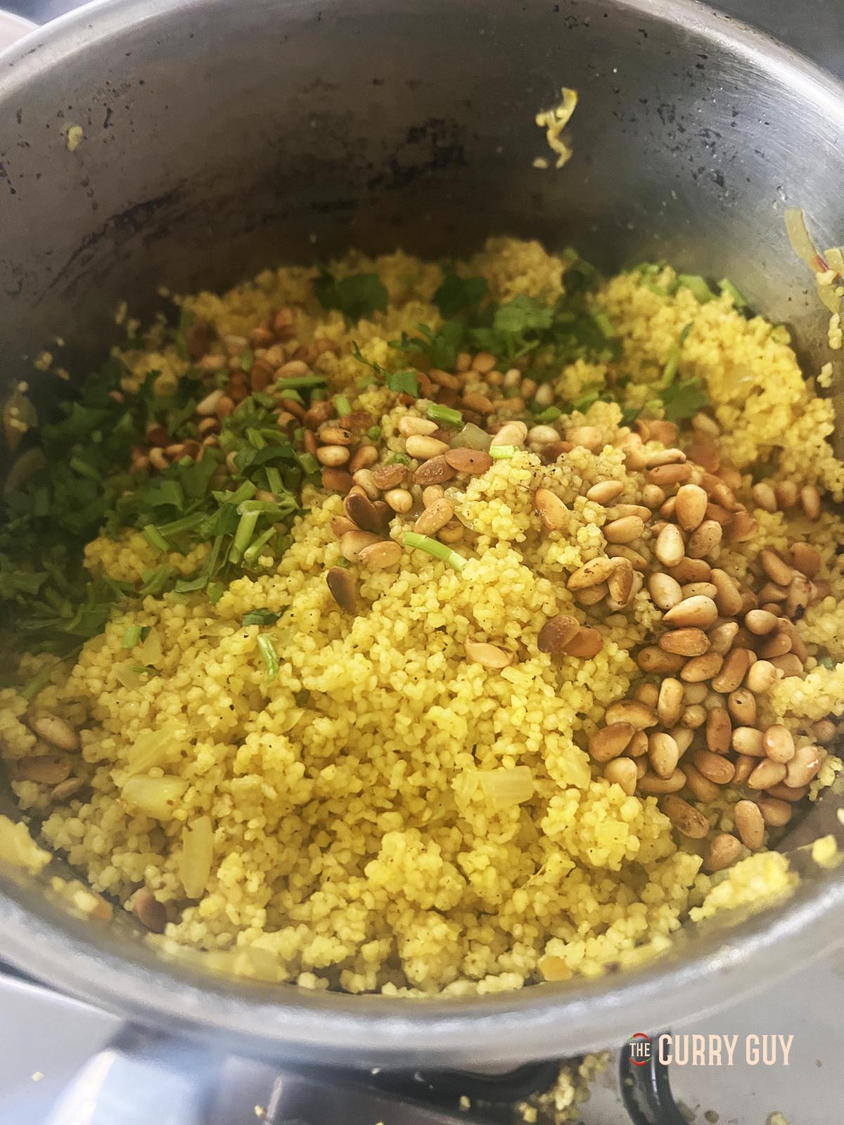 Adding the pine nuts and coriander (cilantro) before seasoning with salt and pepper. 