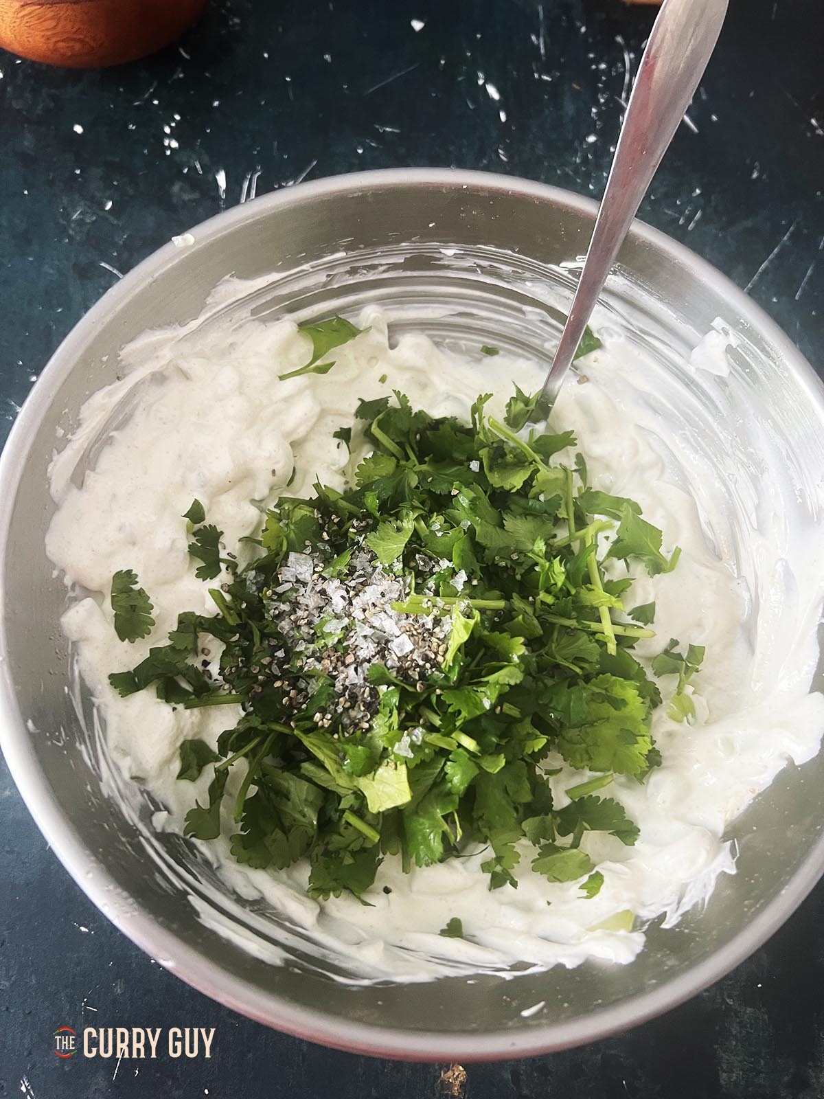 Adding the remaining ingredients to the cucumber raita.