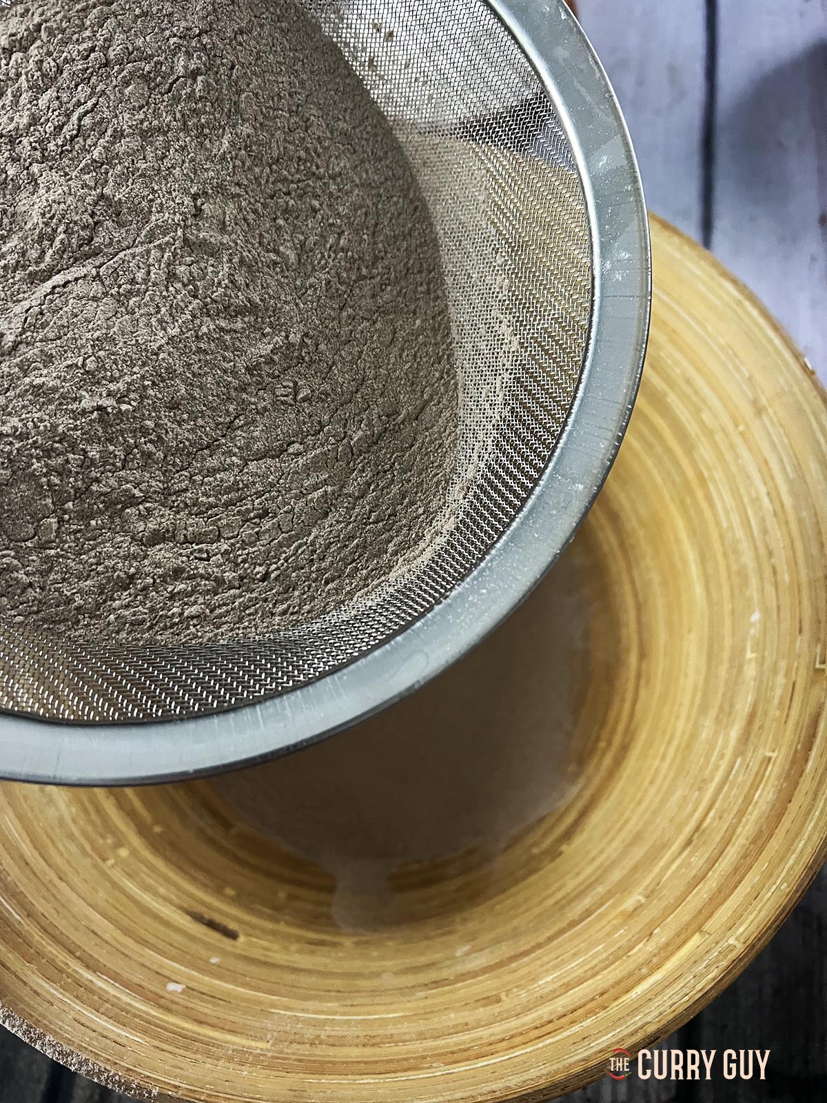 Sifting the flours into a mixing bowl.