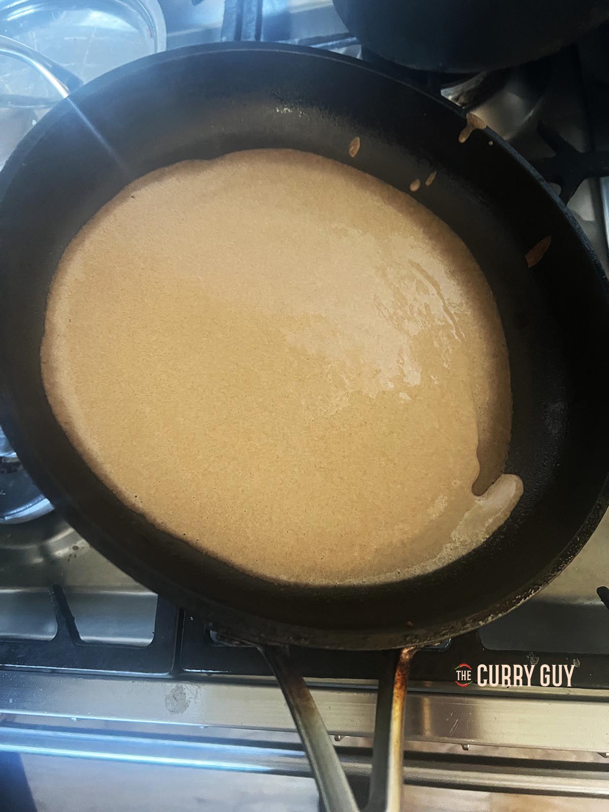 Swirling the batter around in the pan.