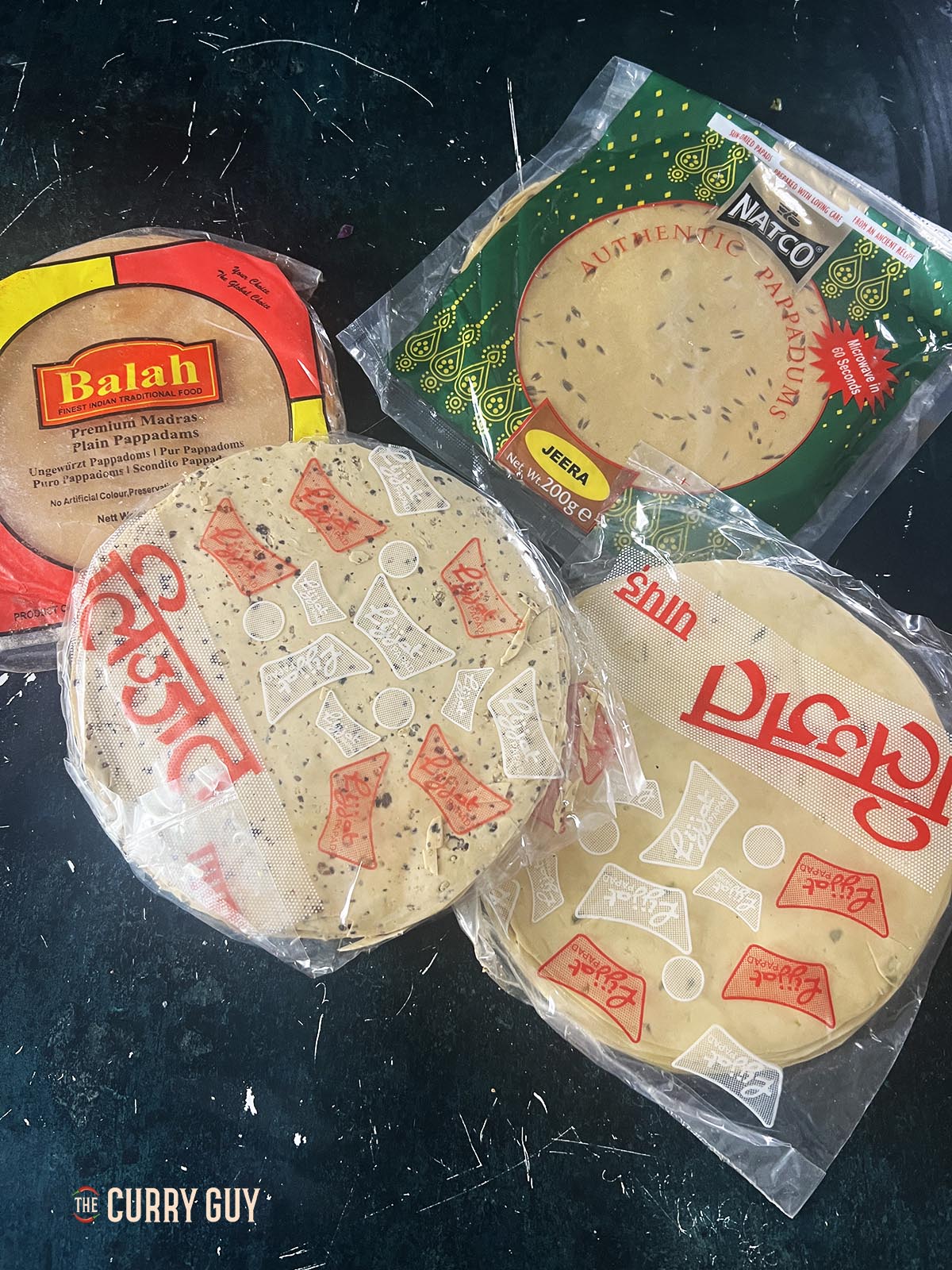 Papads with different flavours; black pepper, green chilli, cumin and plain.
