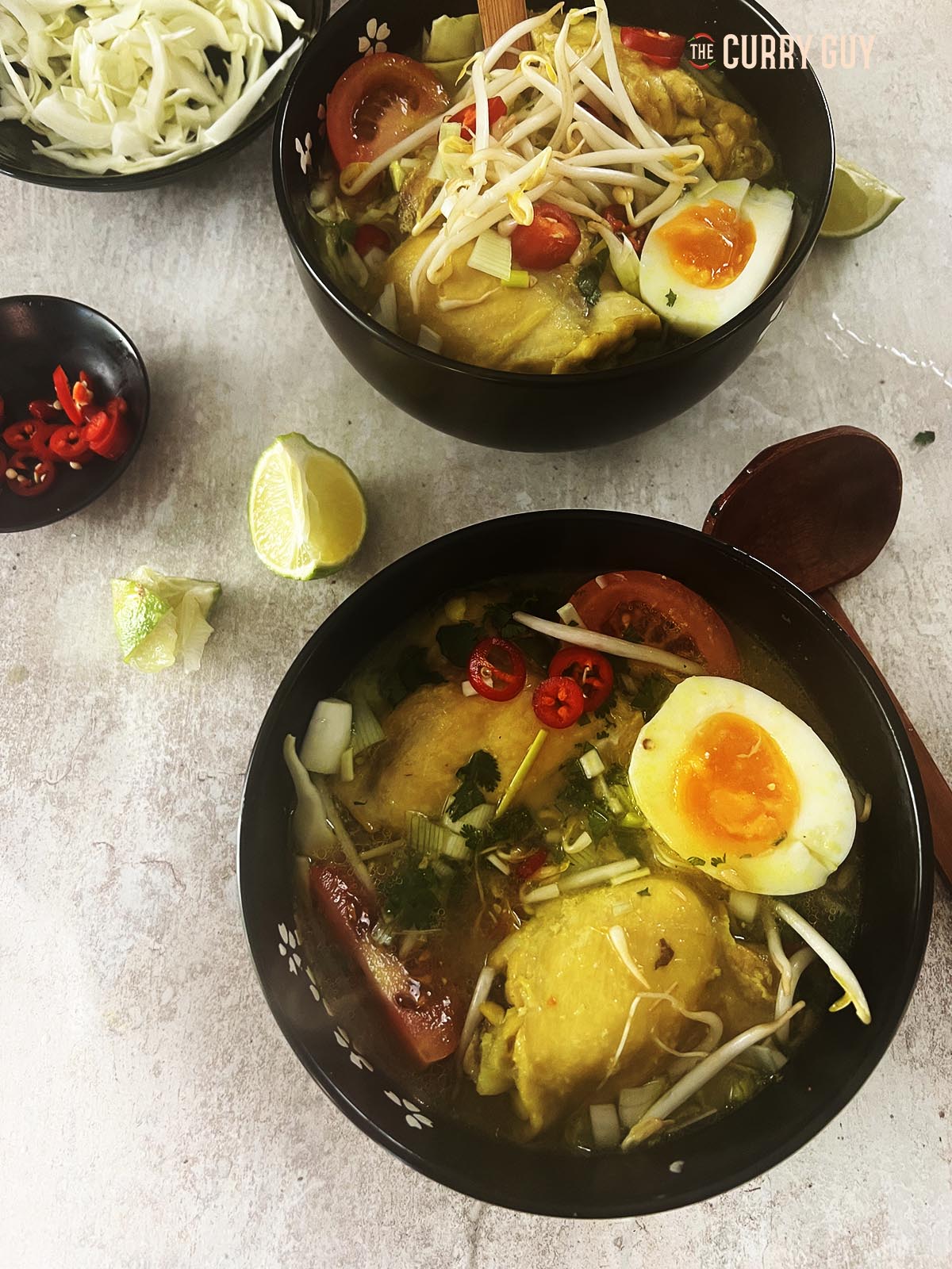 Garnishing the soup with hard boiled egg, chillies, bean sprouts and coriander (cilantro. Then the stock.