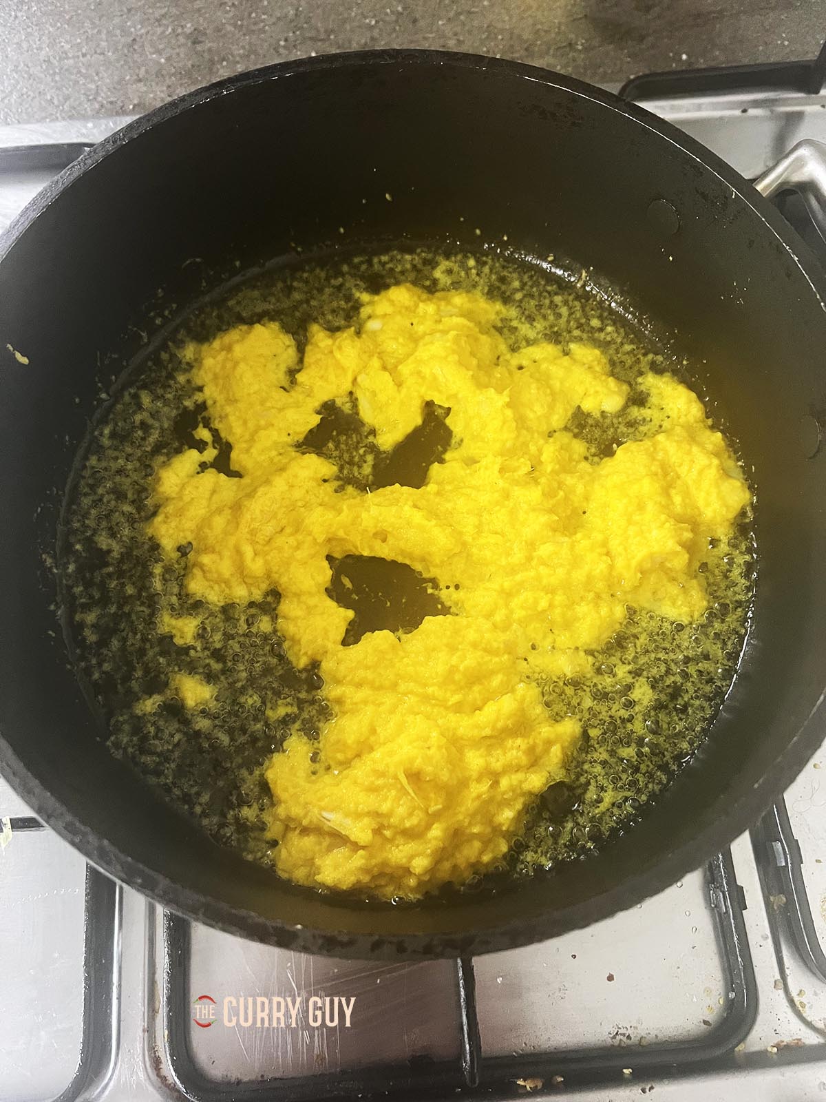 Frying the spice paste in oil.