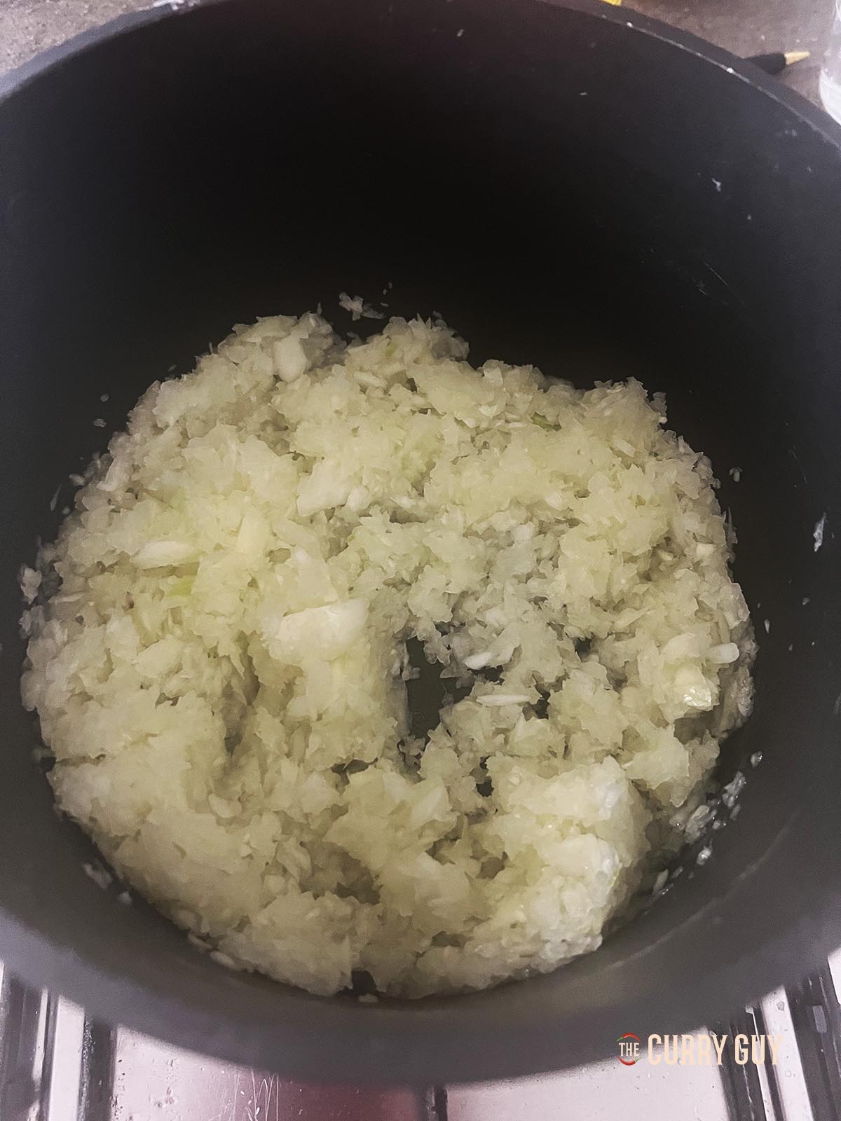 Adding chopped onions to the pan.