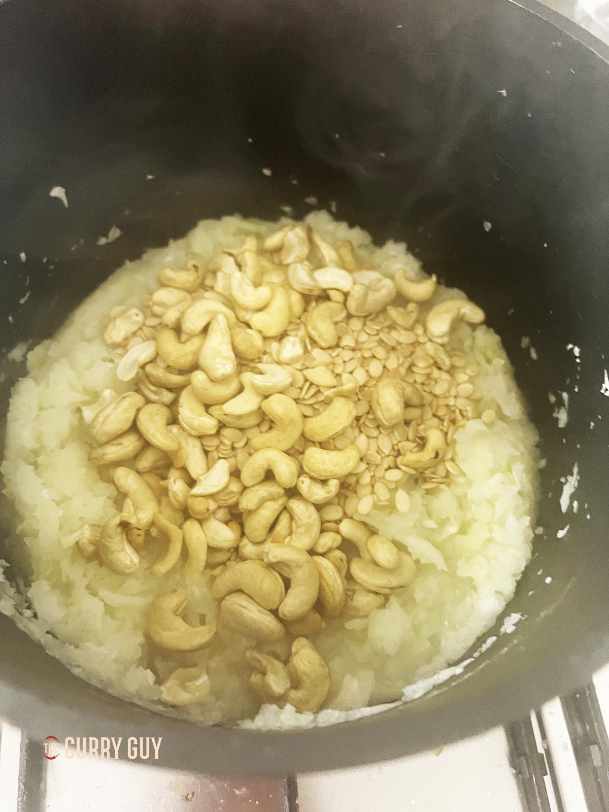Adding the cashews and melon seeds to the pan.