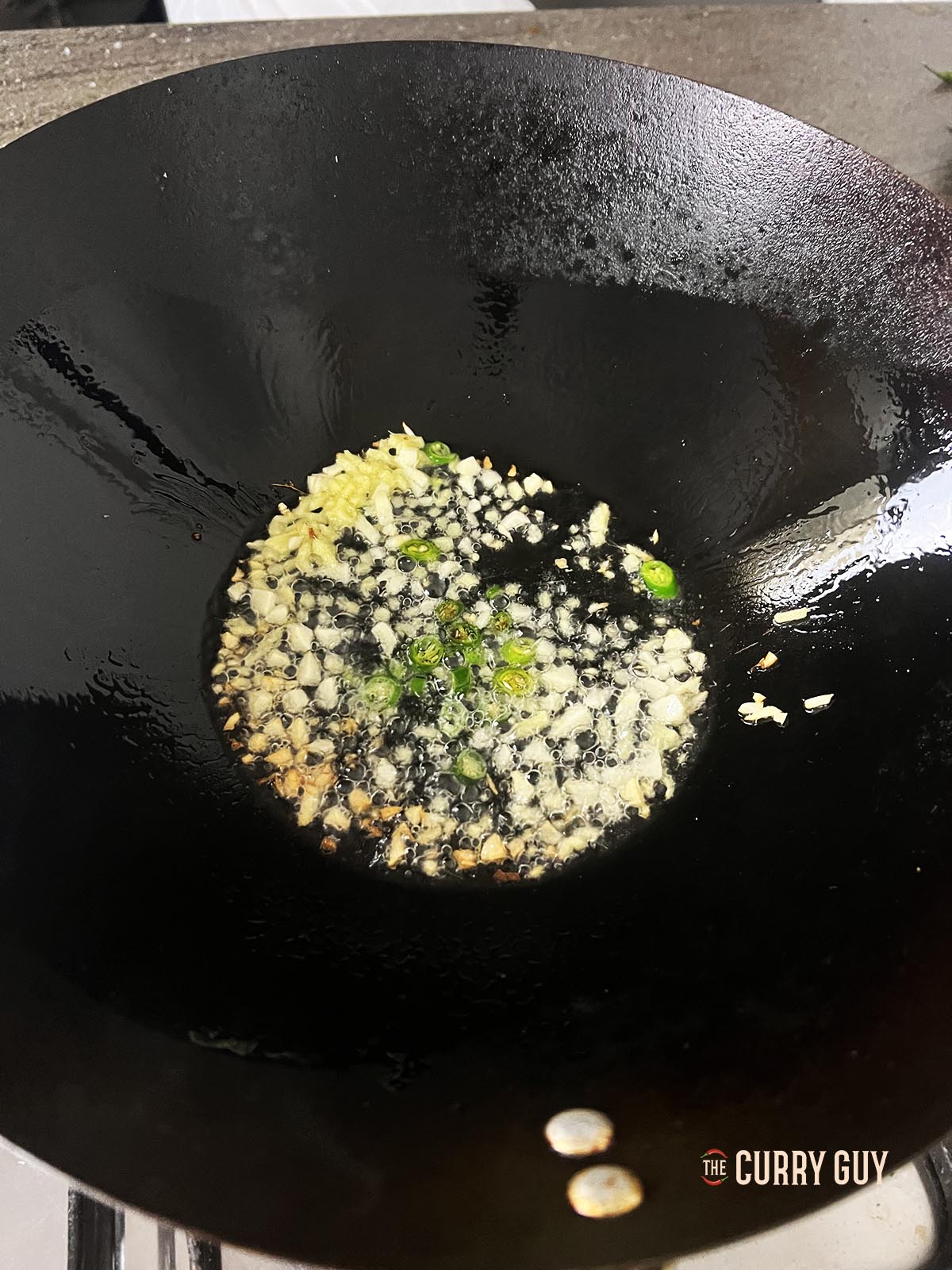 Adding the chillies to the pan.