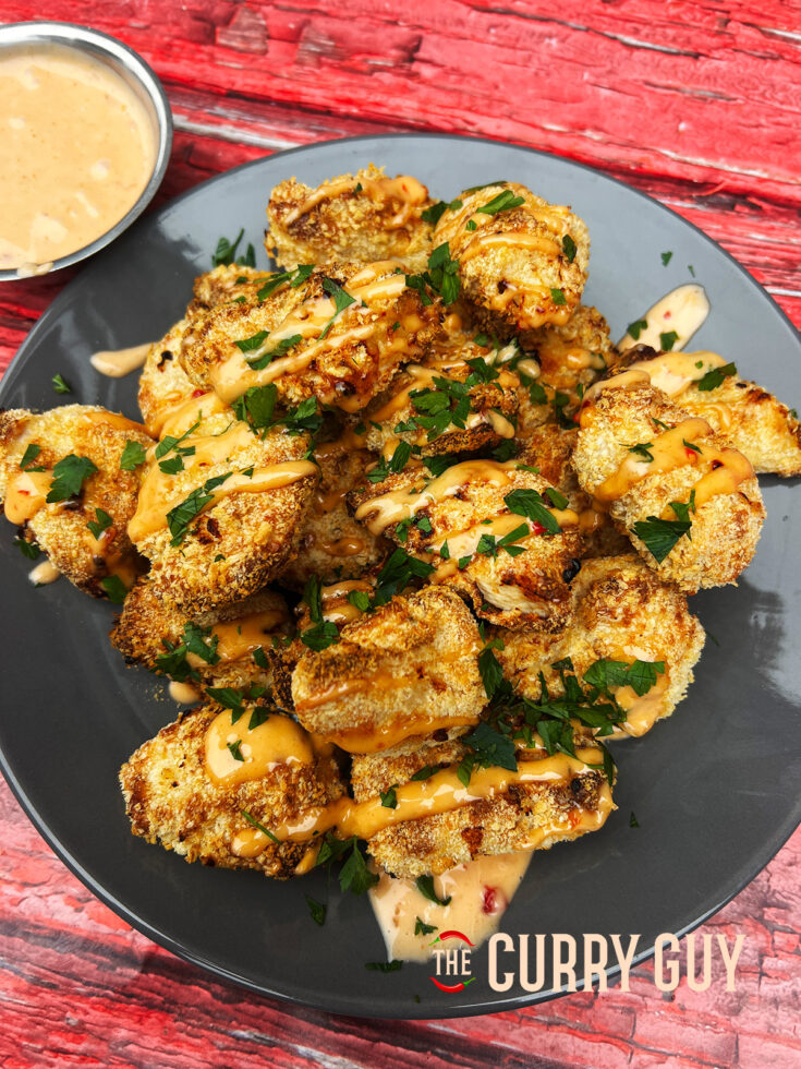 Air fryer bang bang chicken garnished and ready to eat on a plate.