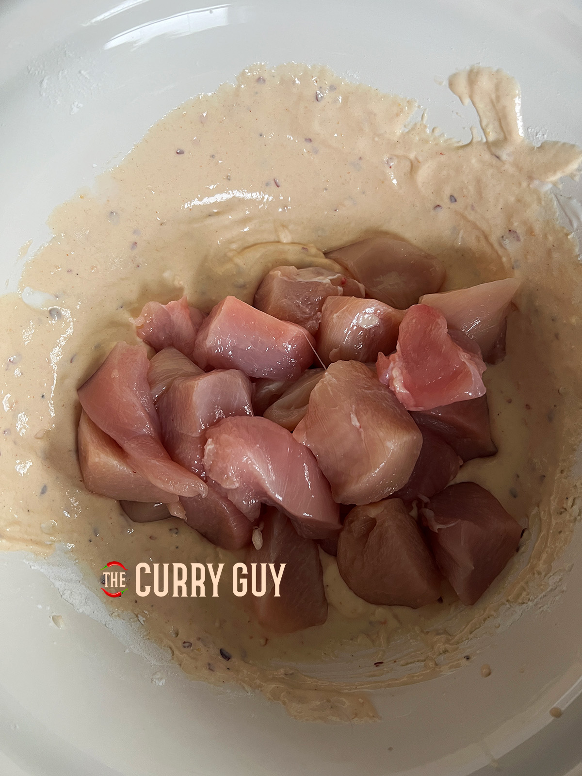 Chicken added to the thick batter in a bowl