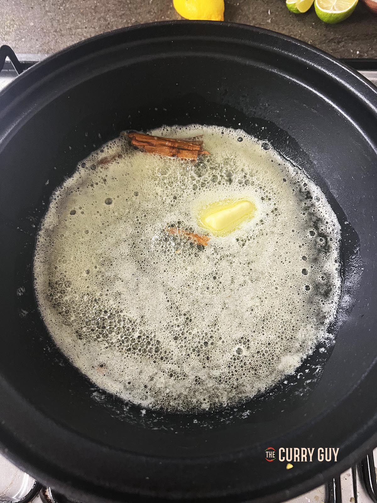 Melting the butter with the cinnamon stick over a medium heat.