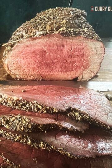 Top round roast cooked rare on a cutting board.