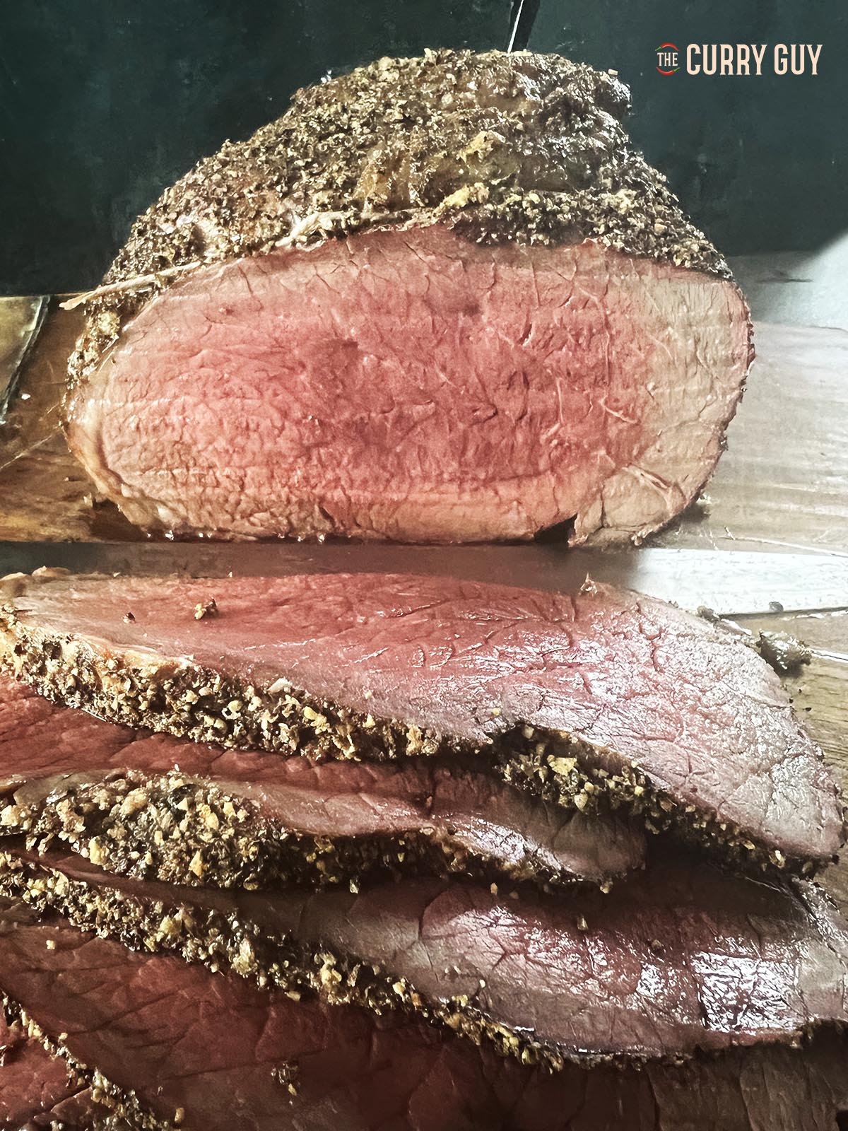 Top round roast cooked rare on a cutting board.