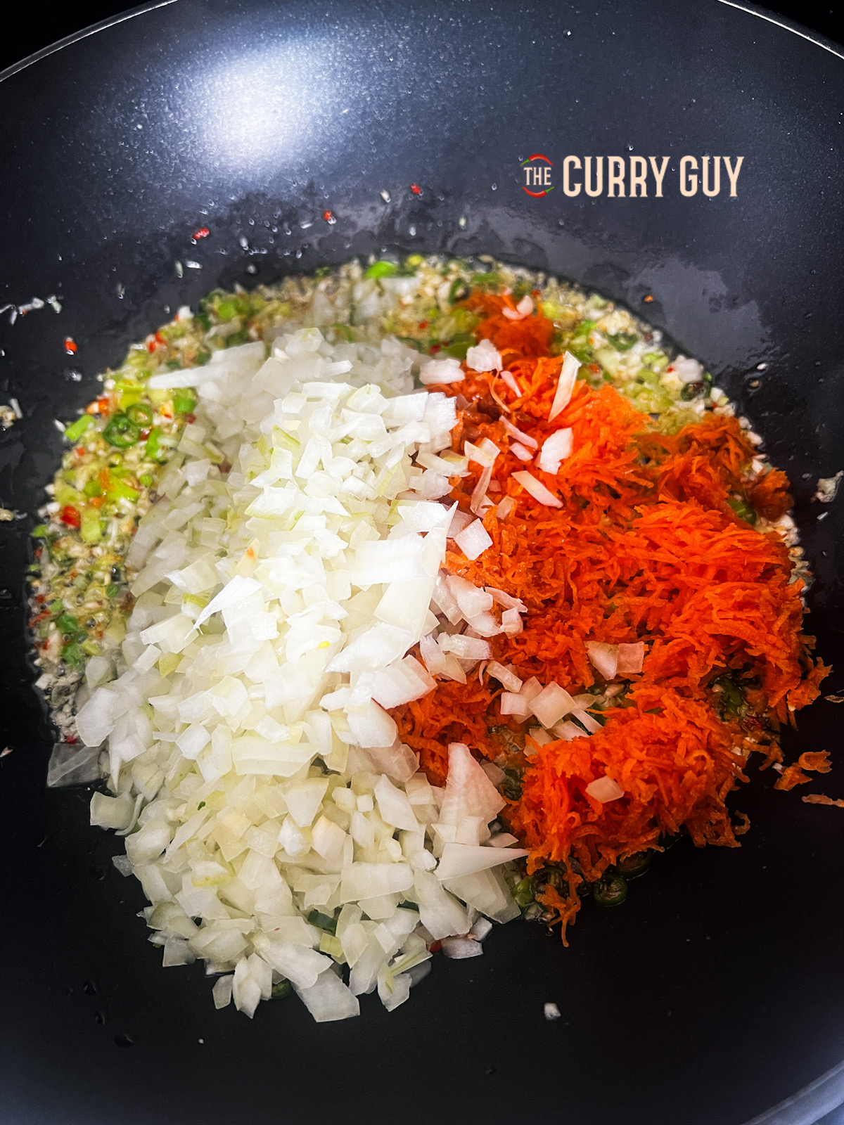 adding onions and carrot to the pan 