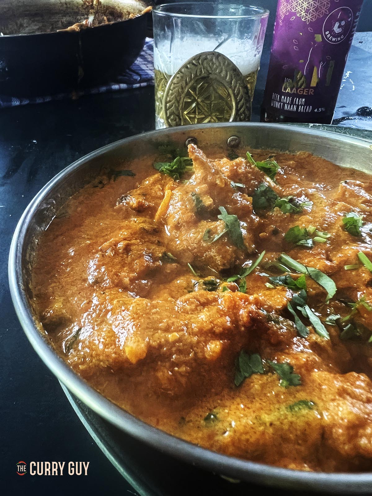 Chicken Rezala served in a balti dish at the table.