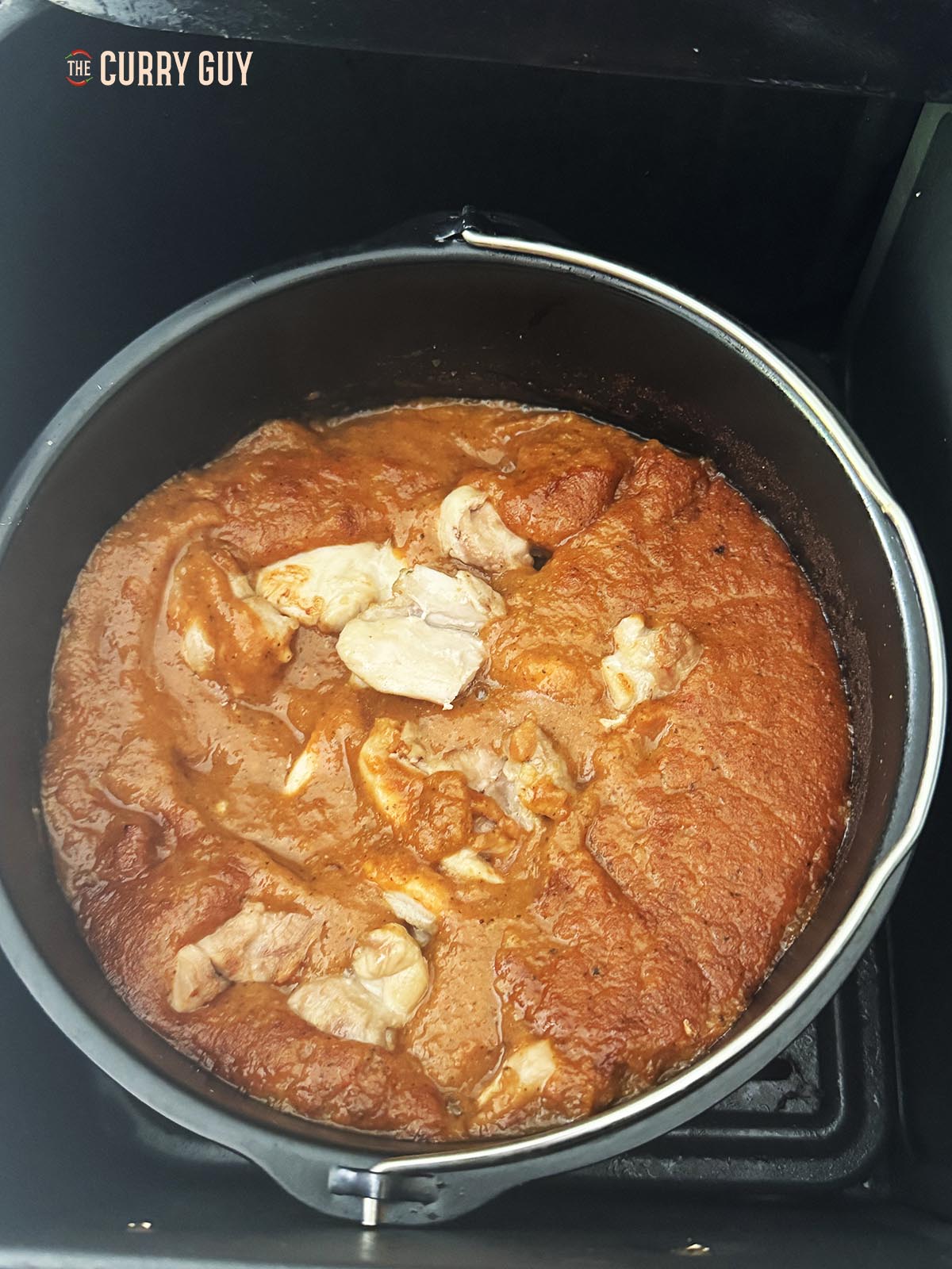 Adding the chicken to the curry.