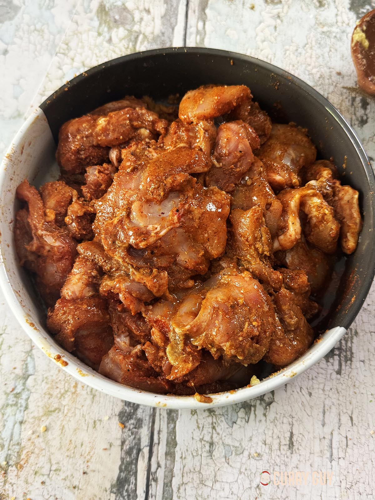 The chicken marinating in a bowl.