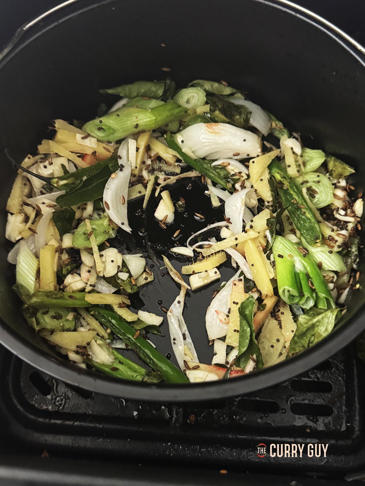 Tempering the whole spices and aromatic ingredients in oil.