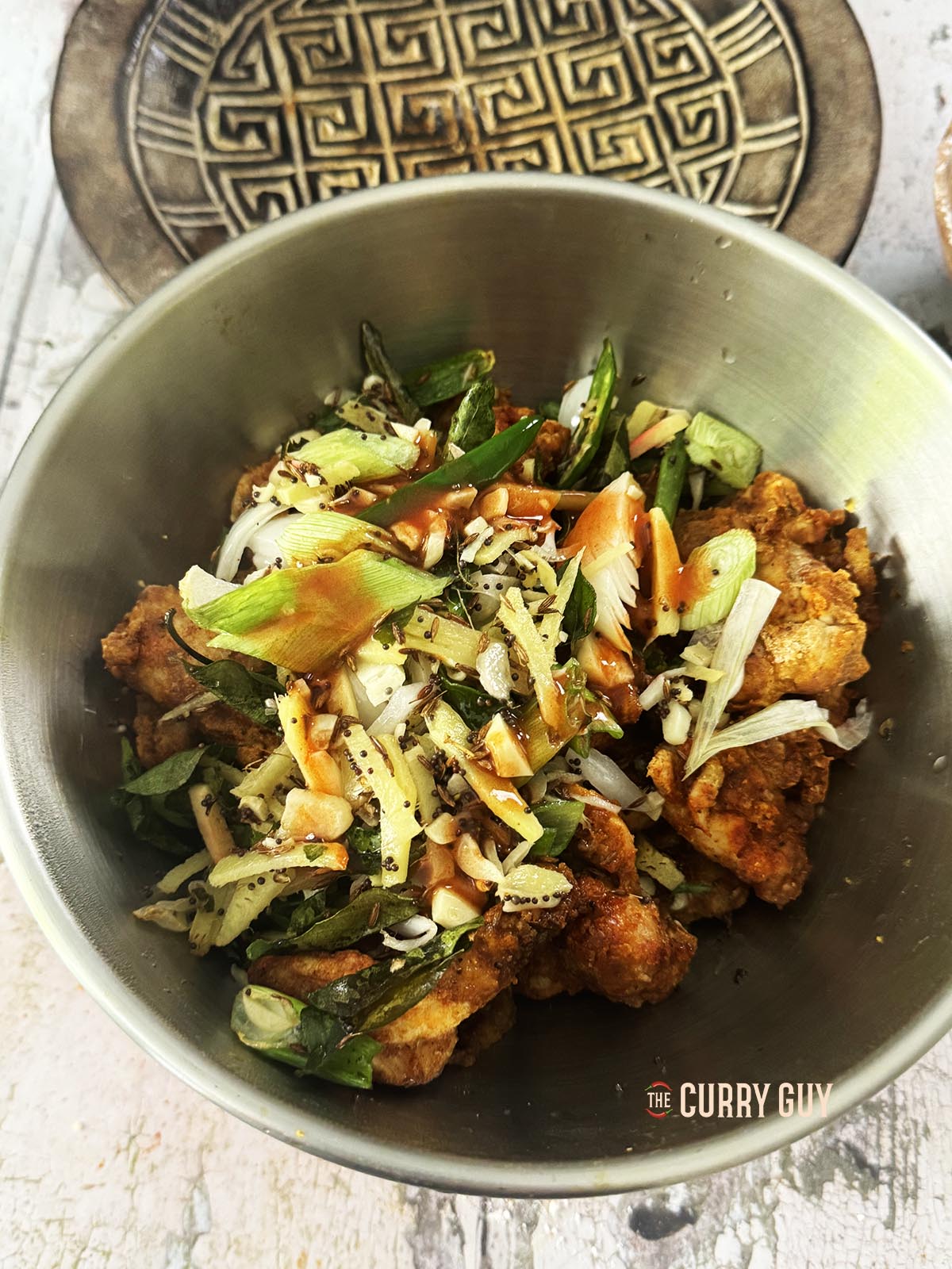 Tossing the chicken with the tempered ingredients.