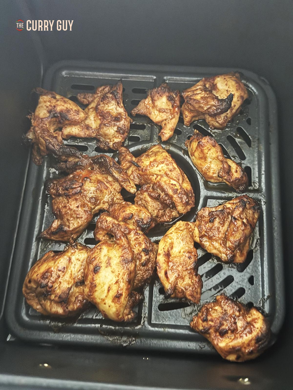 Cooking the chicken for the curry in the air fryer basket.