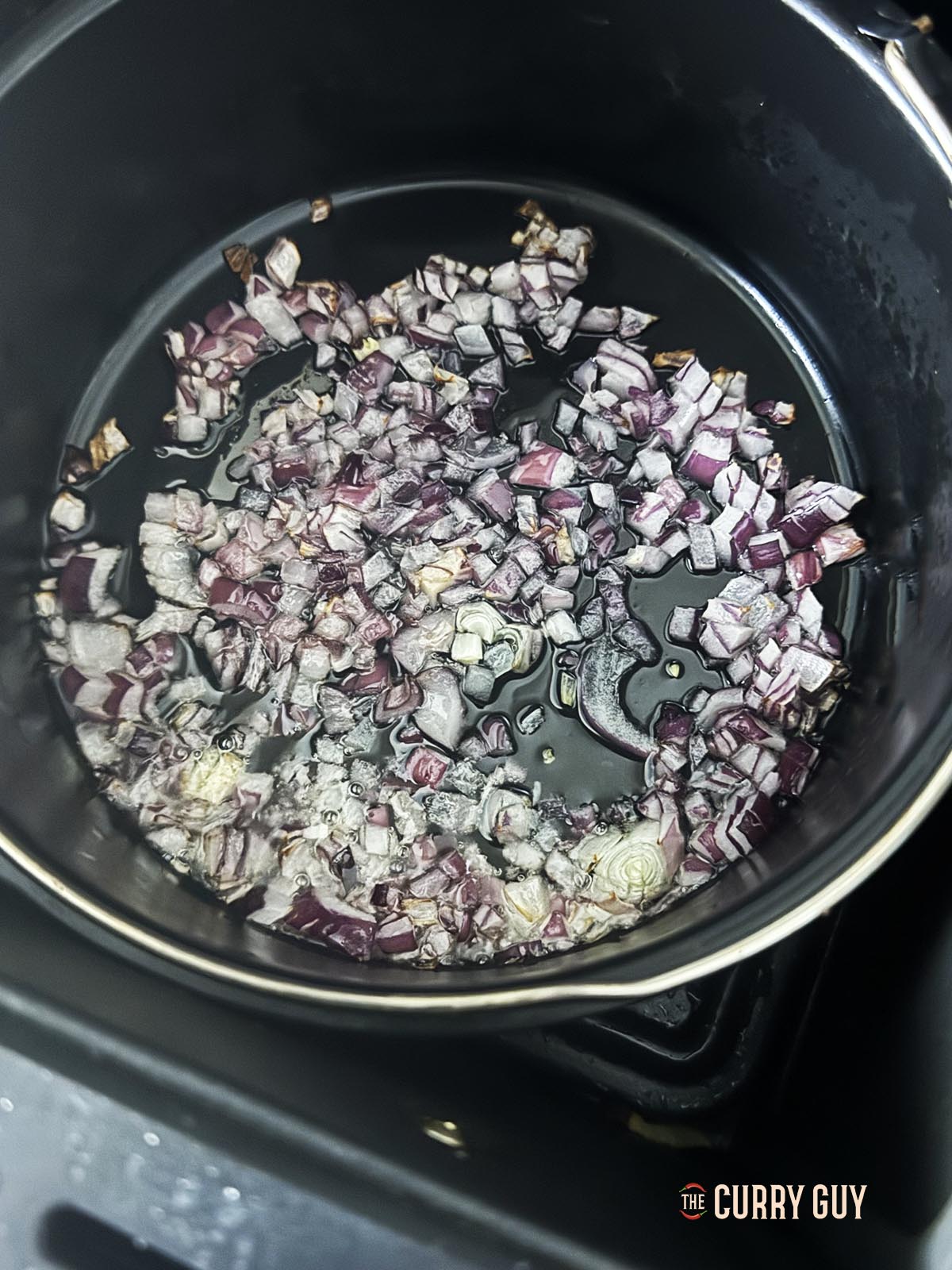 Air frying onions in a cake tin.