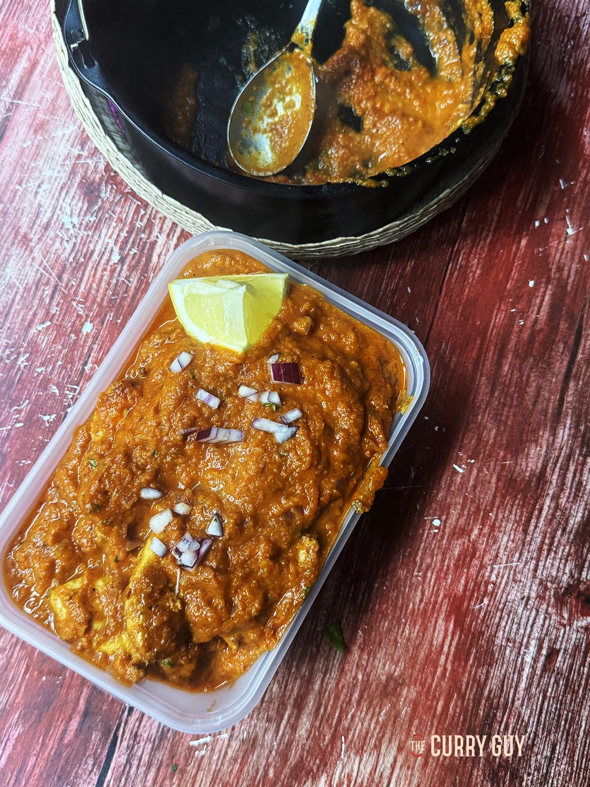 Air fryer chicken pathia in a takeaway container.