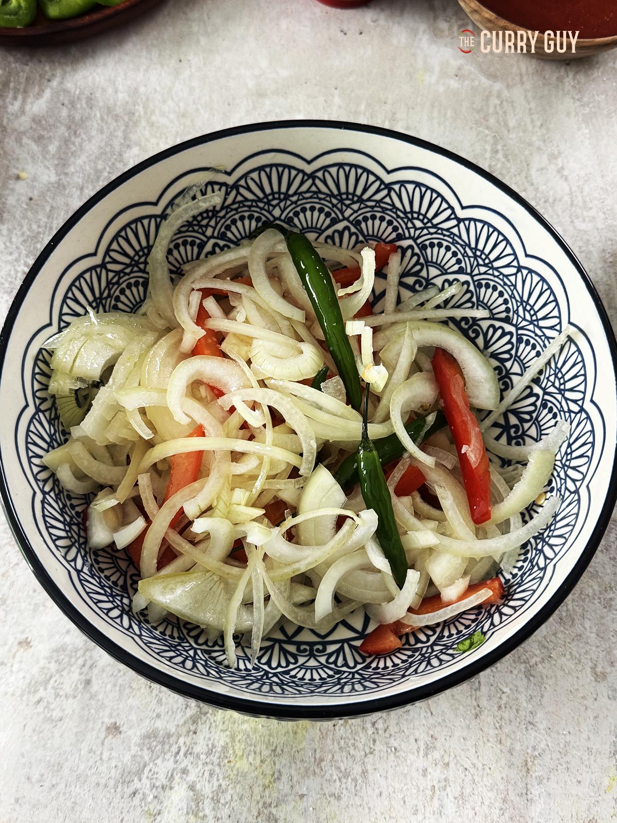 The onions, bell pepper, salt and chillies in a mixing bowl with oil.