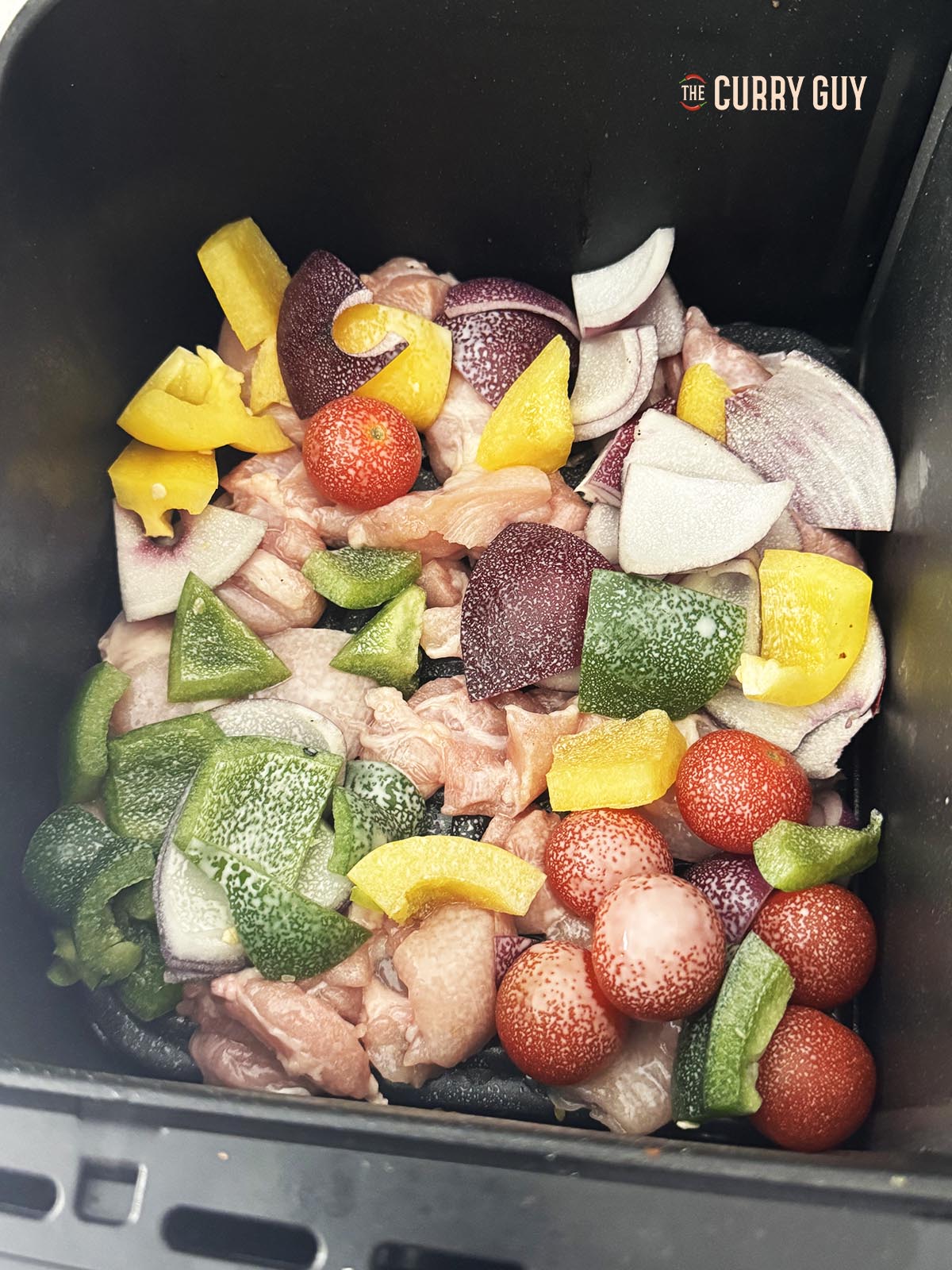 Cooking the chicken and vegetables in the air fryer basket.