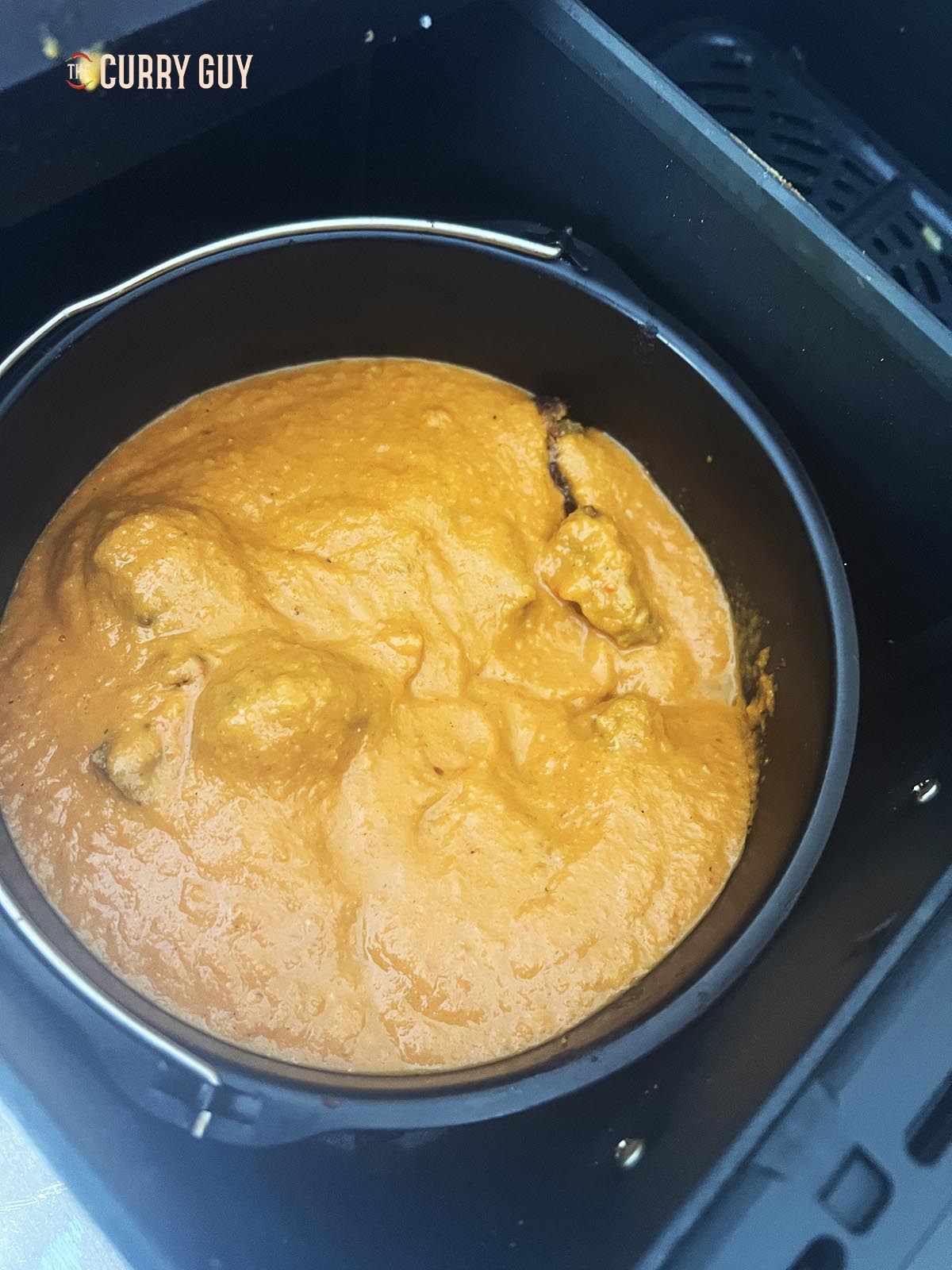 Pouring the curry sauce into the pan.