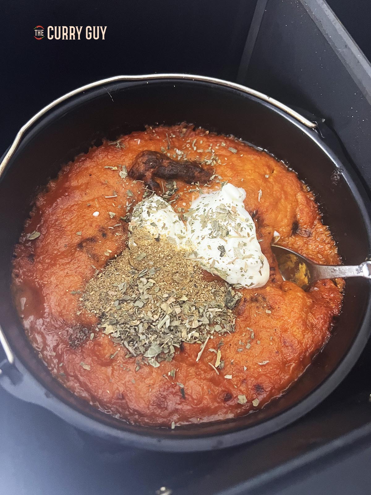 Stirring in the yoghurt, garam masala and kasoori methi.