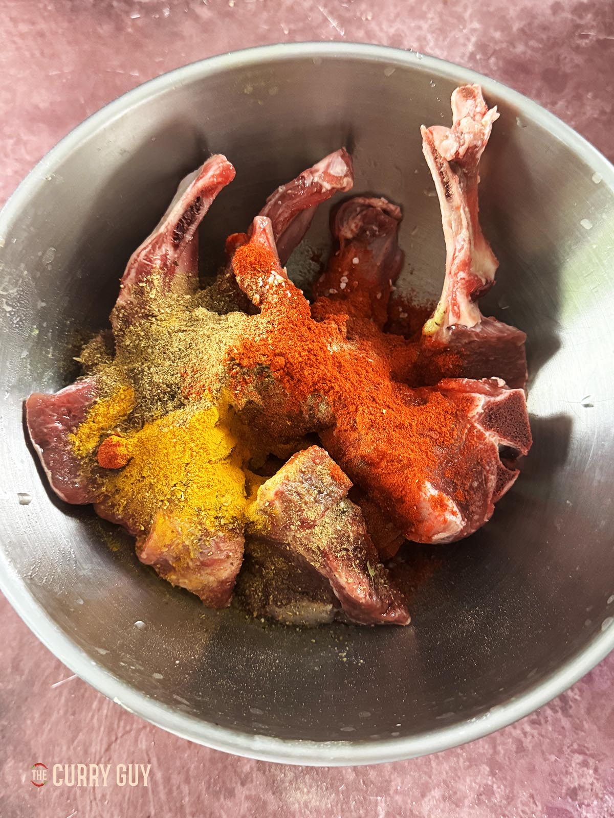 Applying the first marinade to the lamb chops.