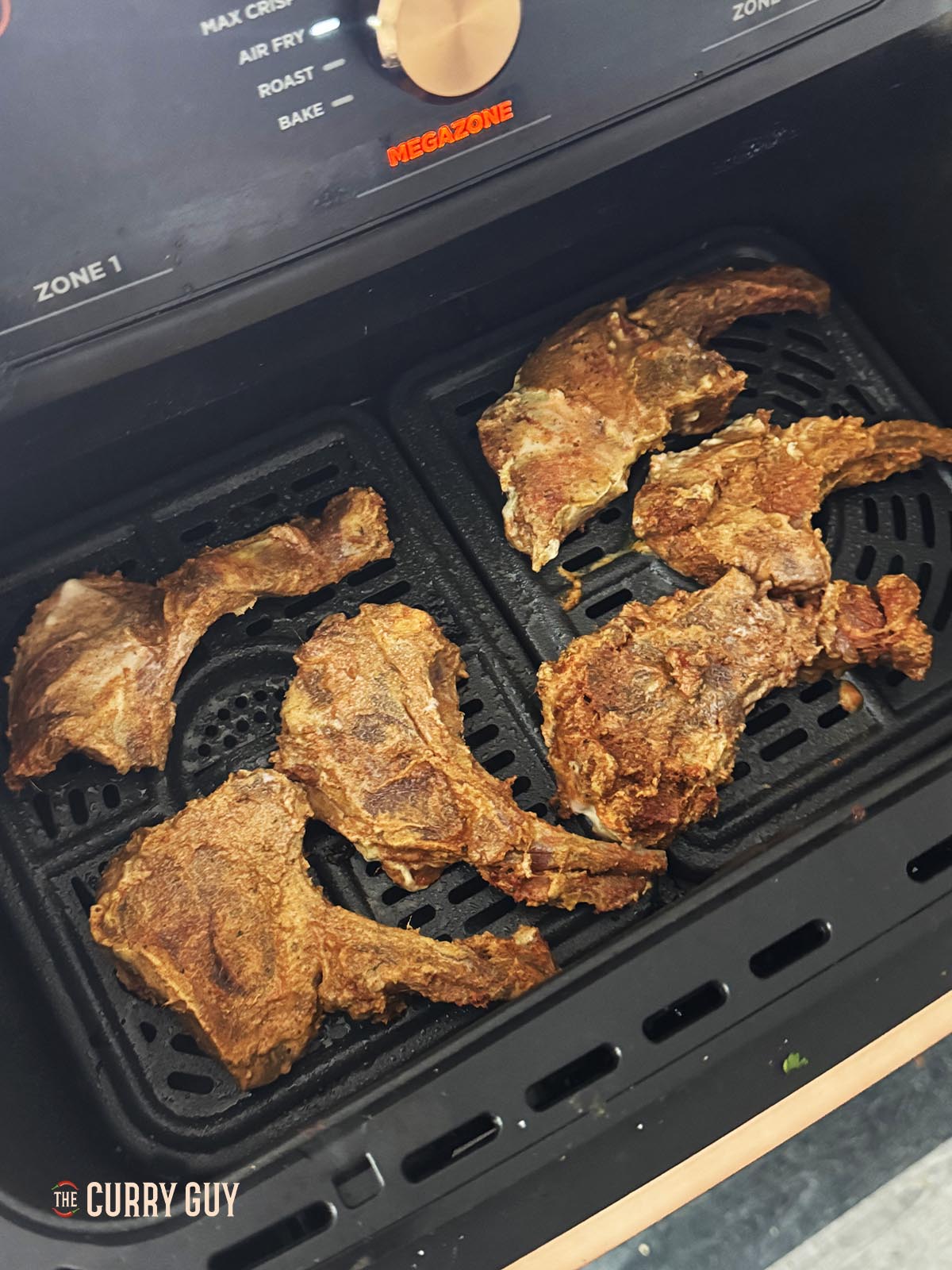 Adding the marinated lamb chops to an air fryer that is preheated to 200°C/400°F.