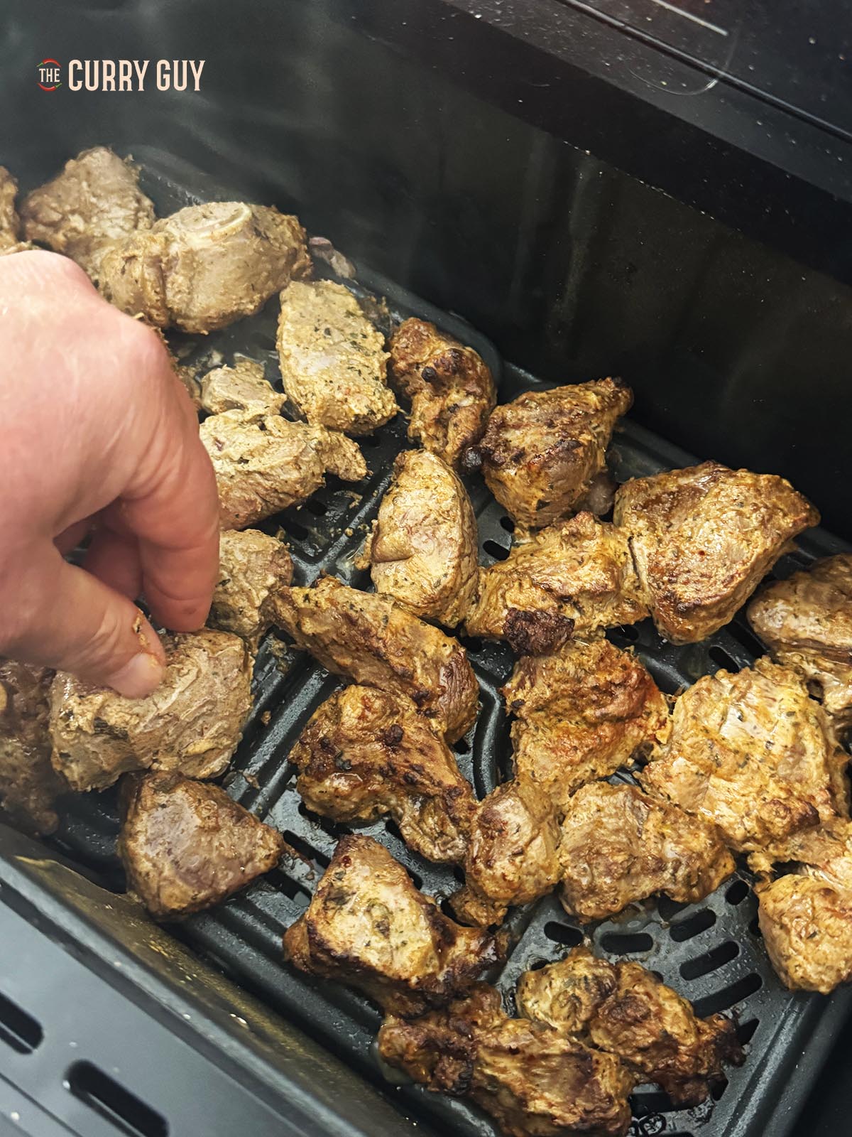 Turning the meat during the cook.