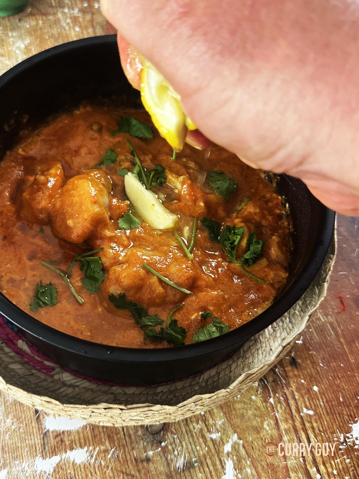 Adding lemon juice to taste to the curry sauce.