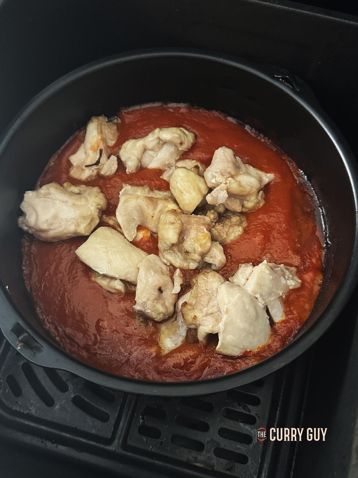 The darkened sauce with chicken in it.