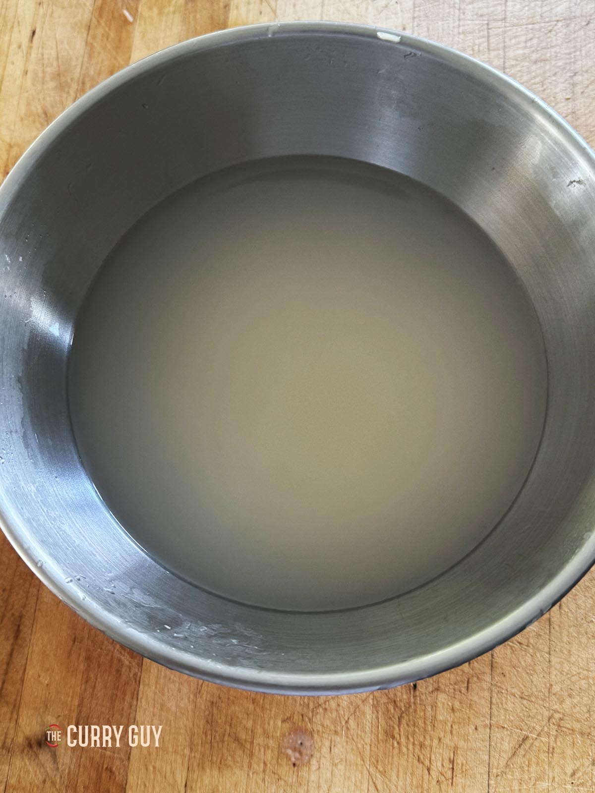 The rice covered with water. The water is milky because of the starch on the rice.