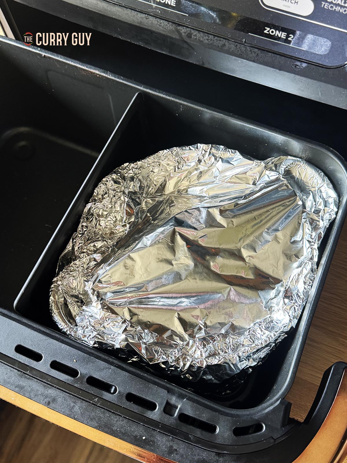 The rice in the air fryer covered tightly with foil.