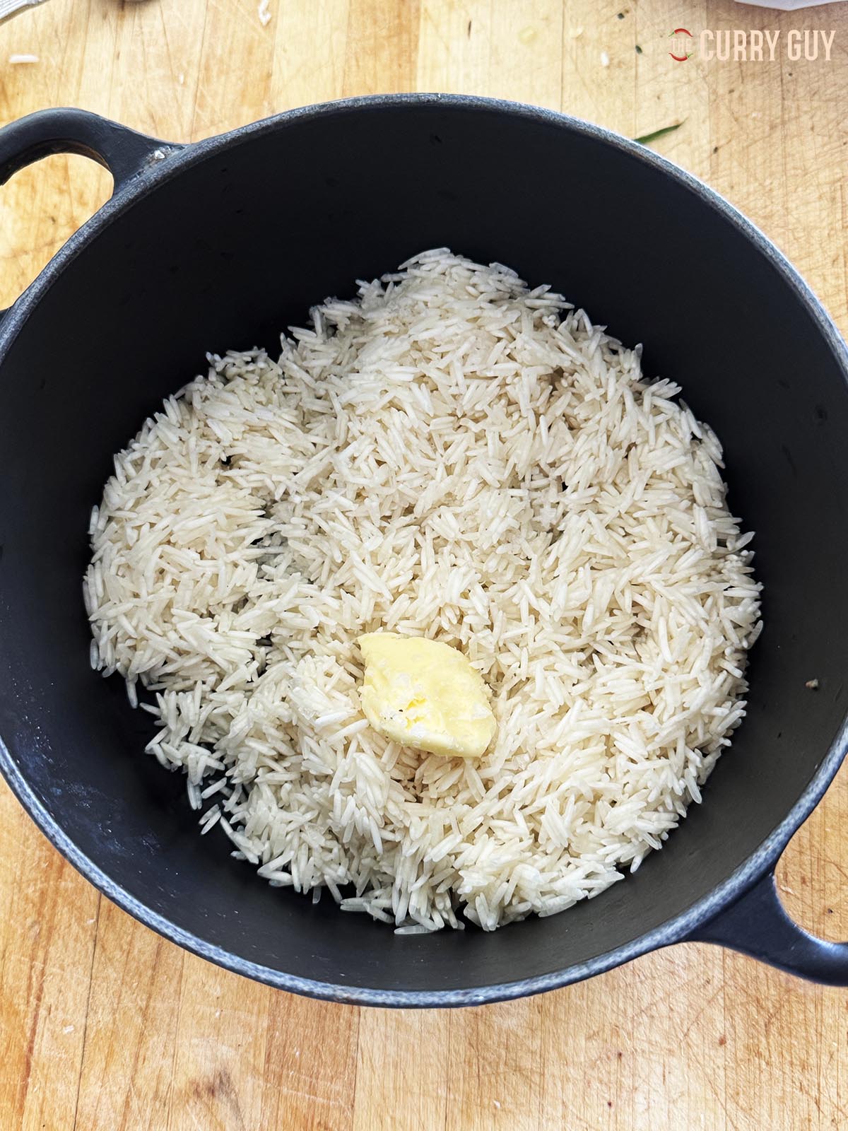 The rice, butter and salt in a metal pan.