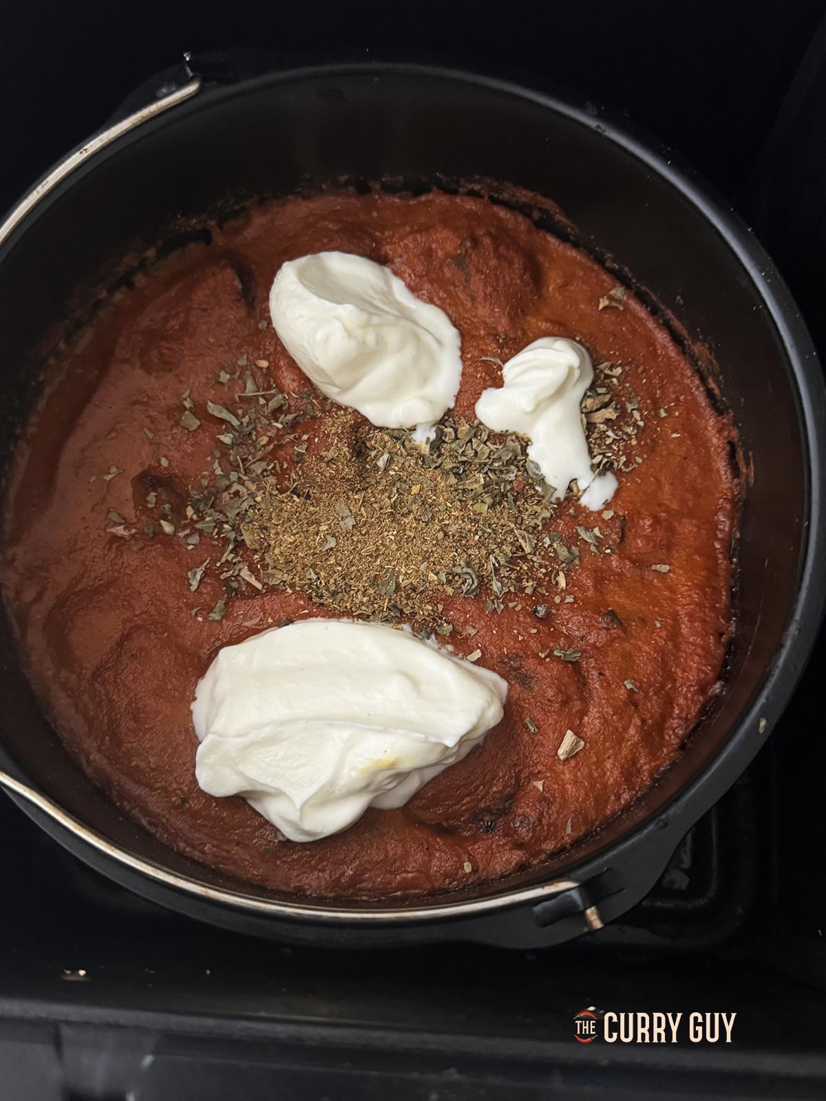 Adding yoghurt, garam masala and kasoori methi to the sauce.