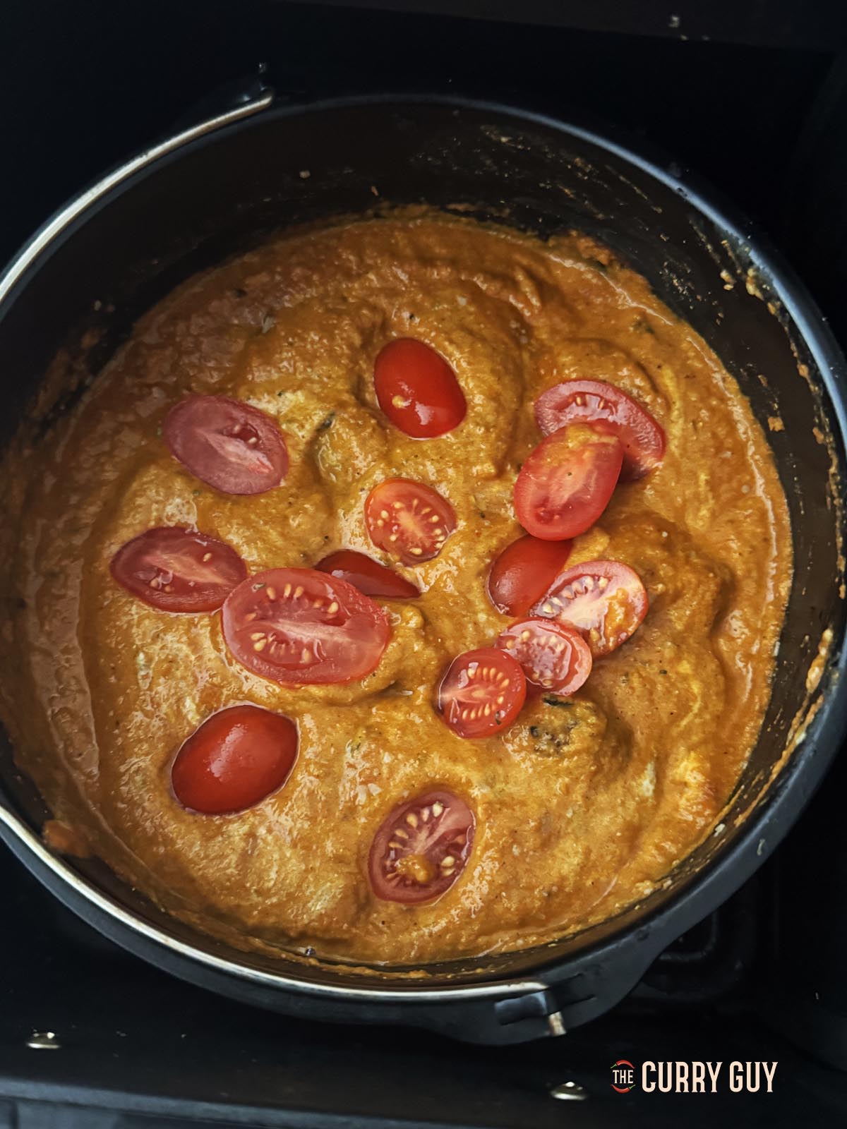 Adding tomatoes to the sauce.
