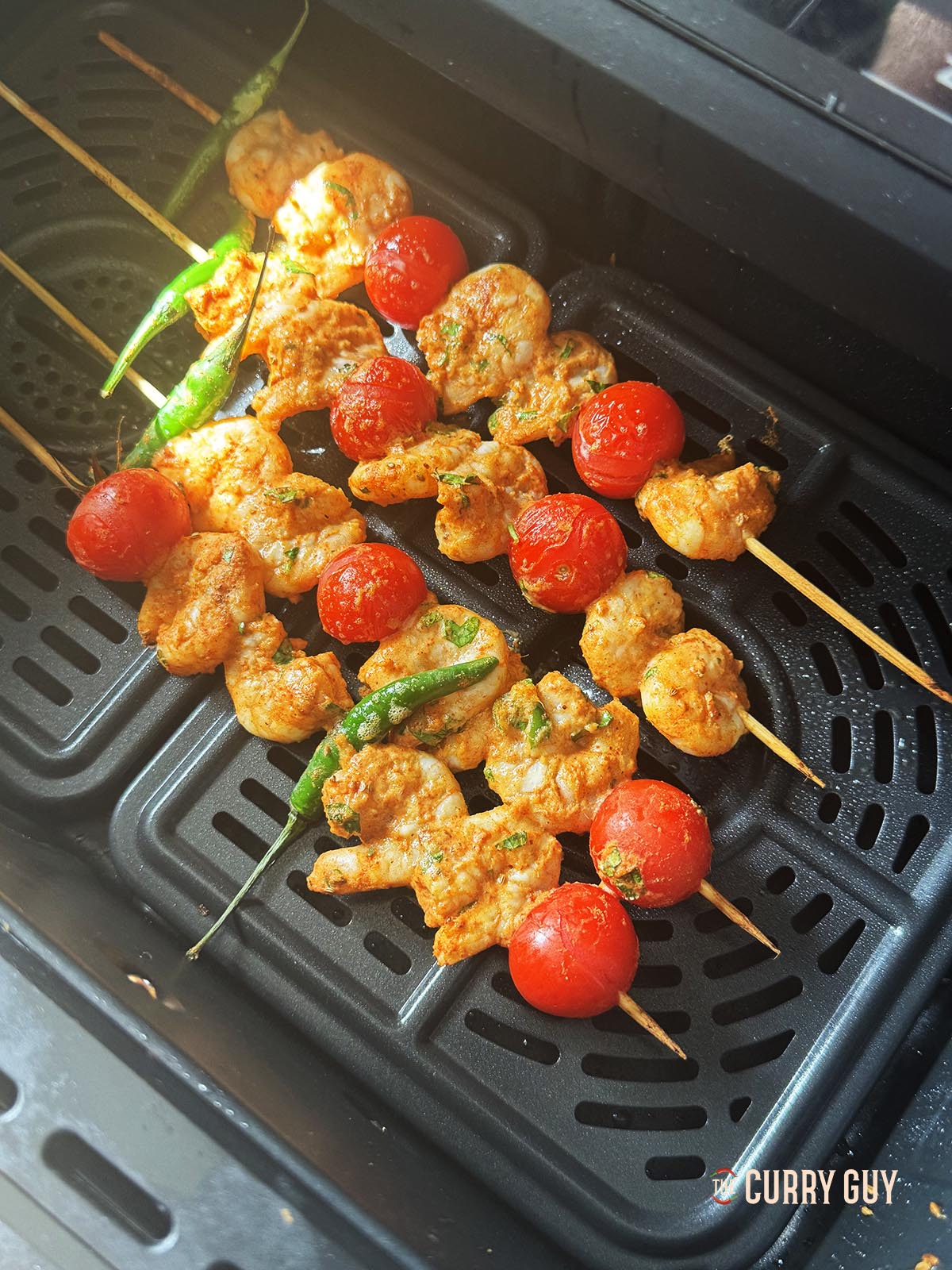 Placing the shrimp skewers in the air fryer.