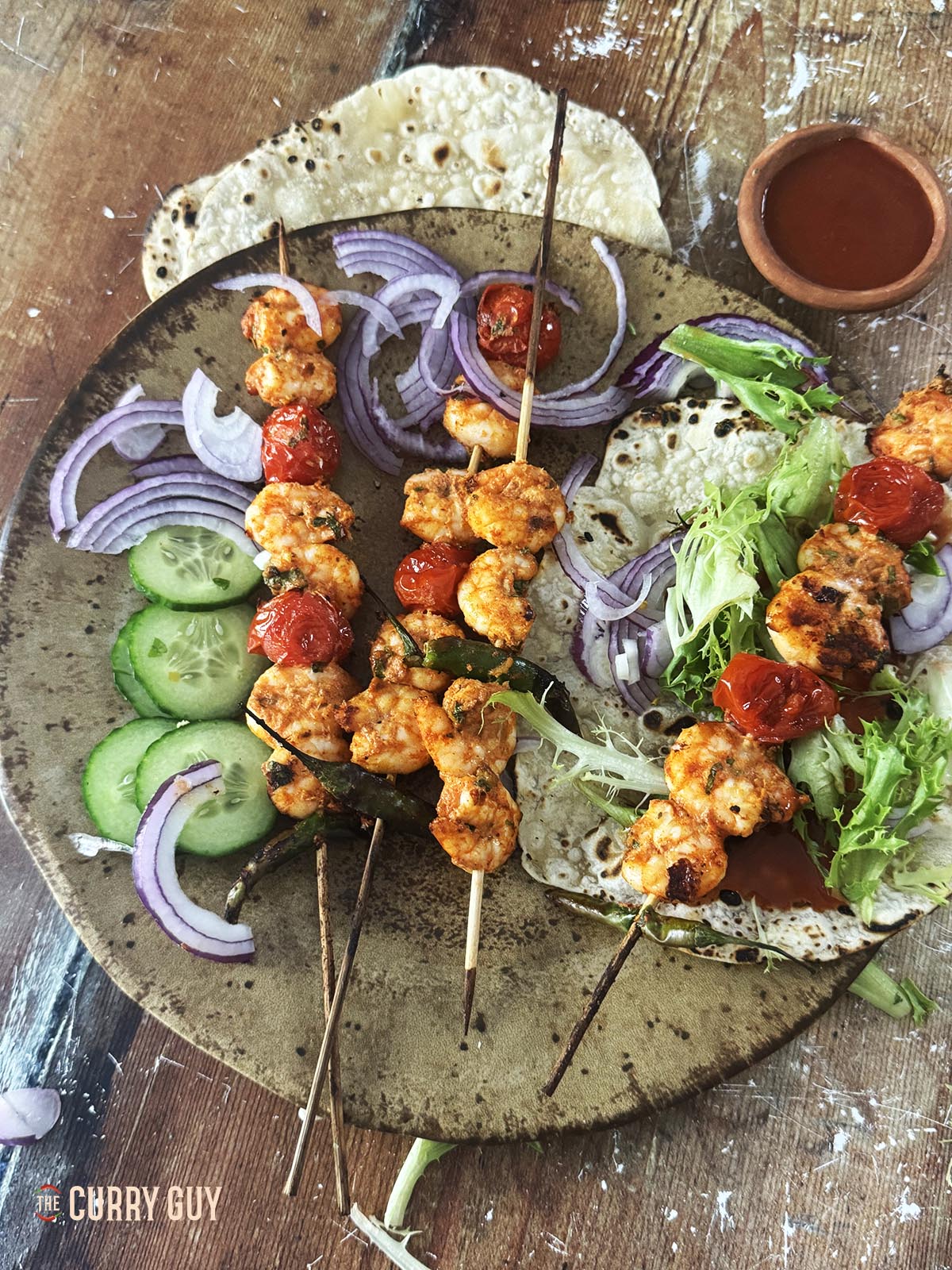 Air fryer shrimp on skewers with tomatoes and other salad vegetables.