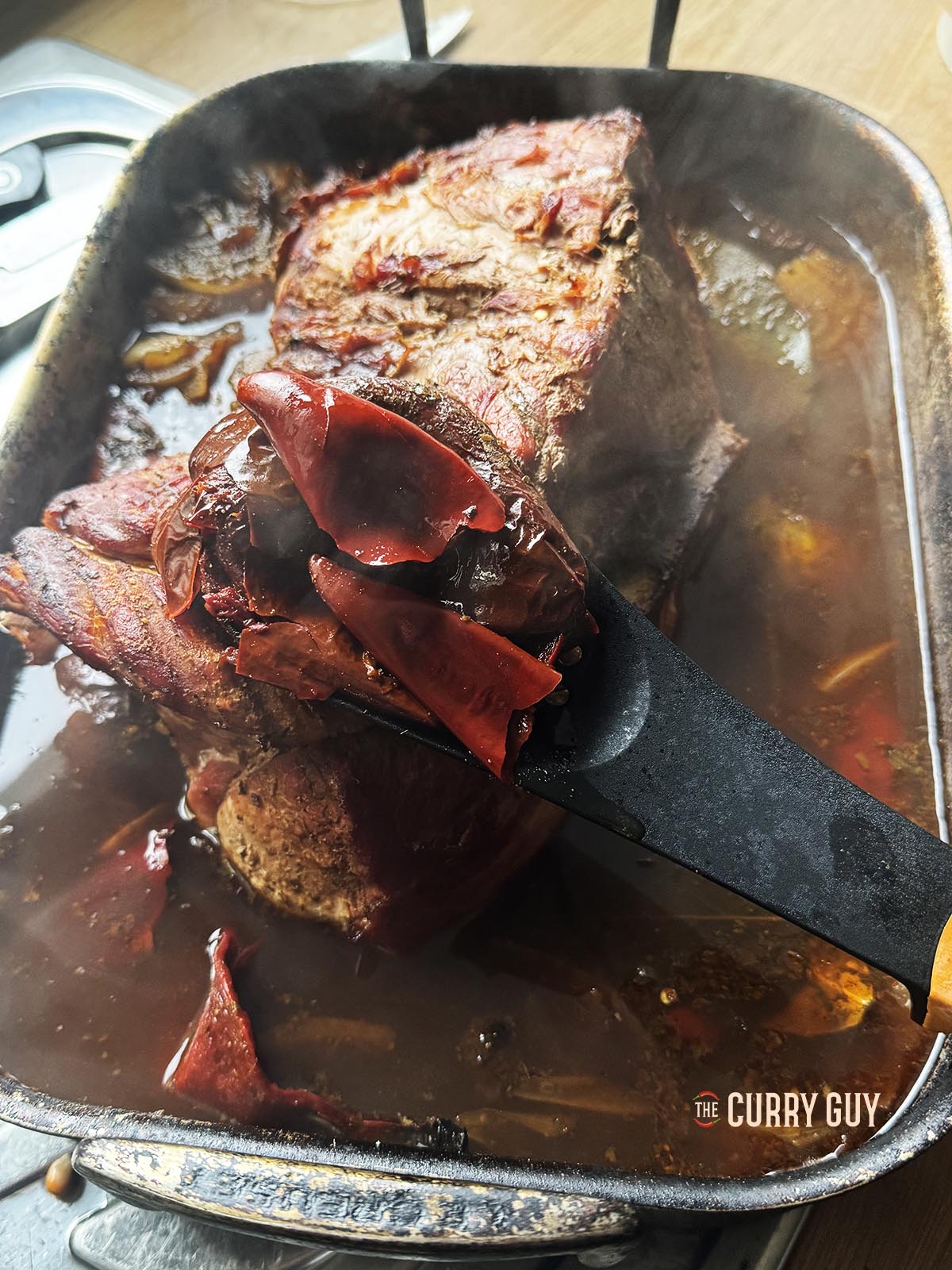 Removing the meat and the whole ingredients from the cooking broth.