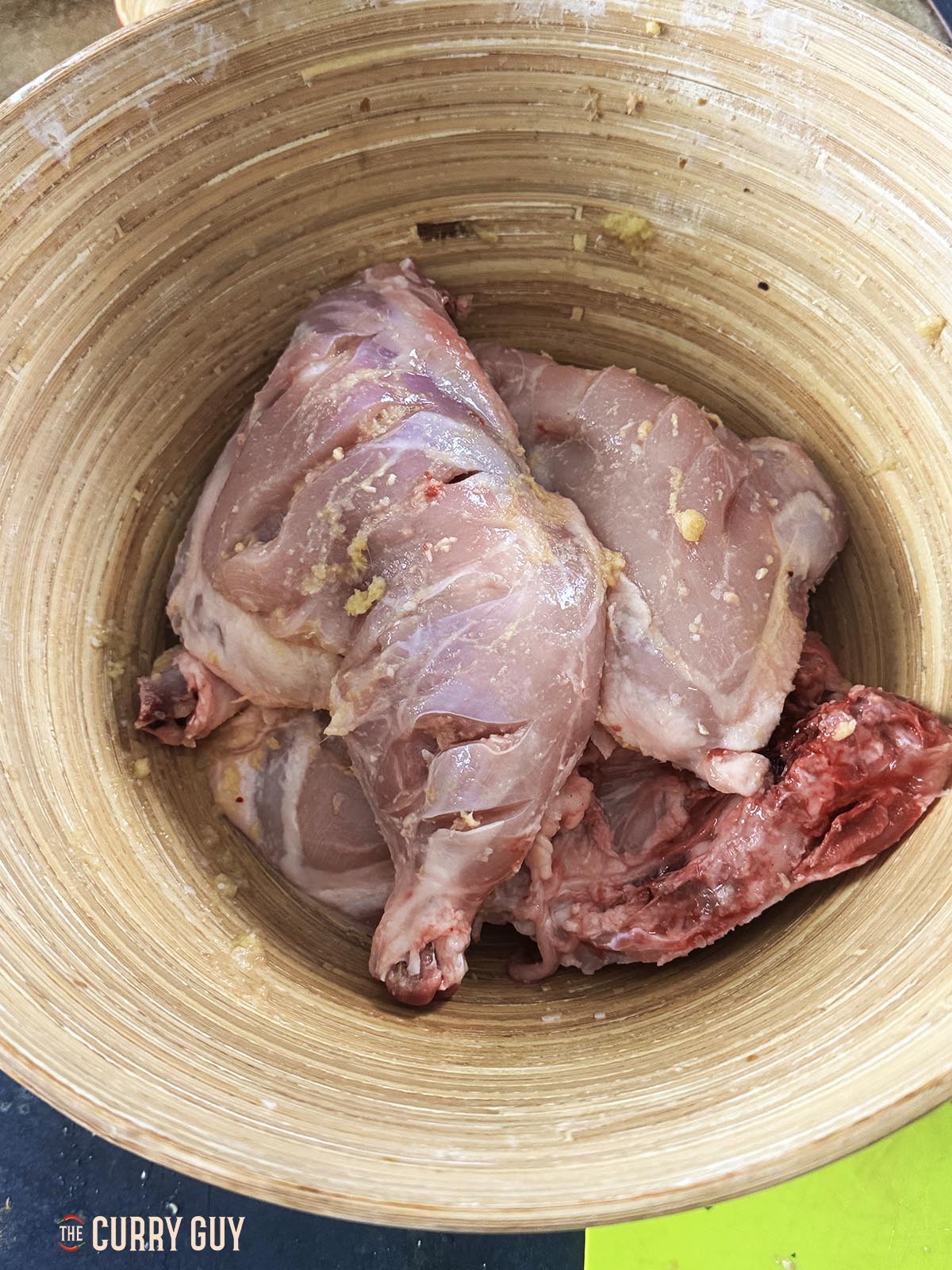 The chicken in a mixing bowl with the first marinade of garlic and ginger paste, salt and lemon juice.